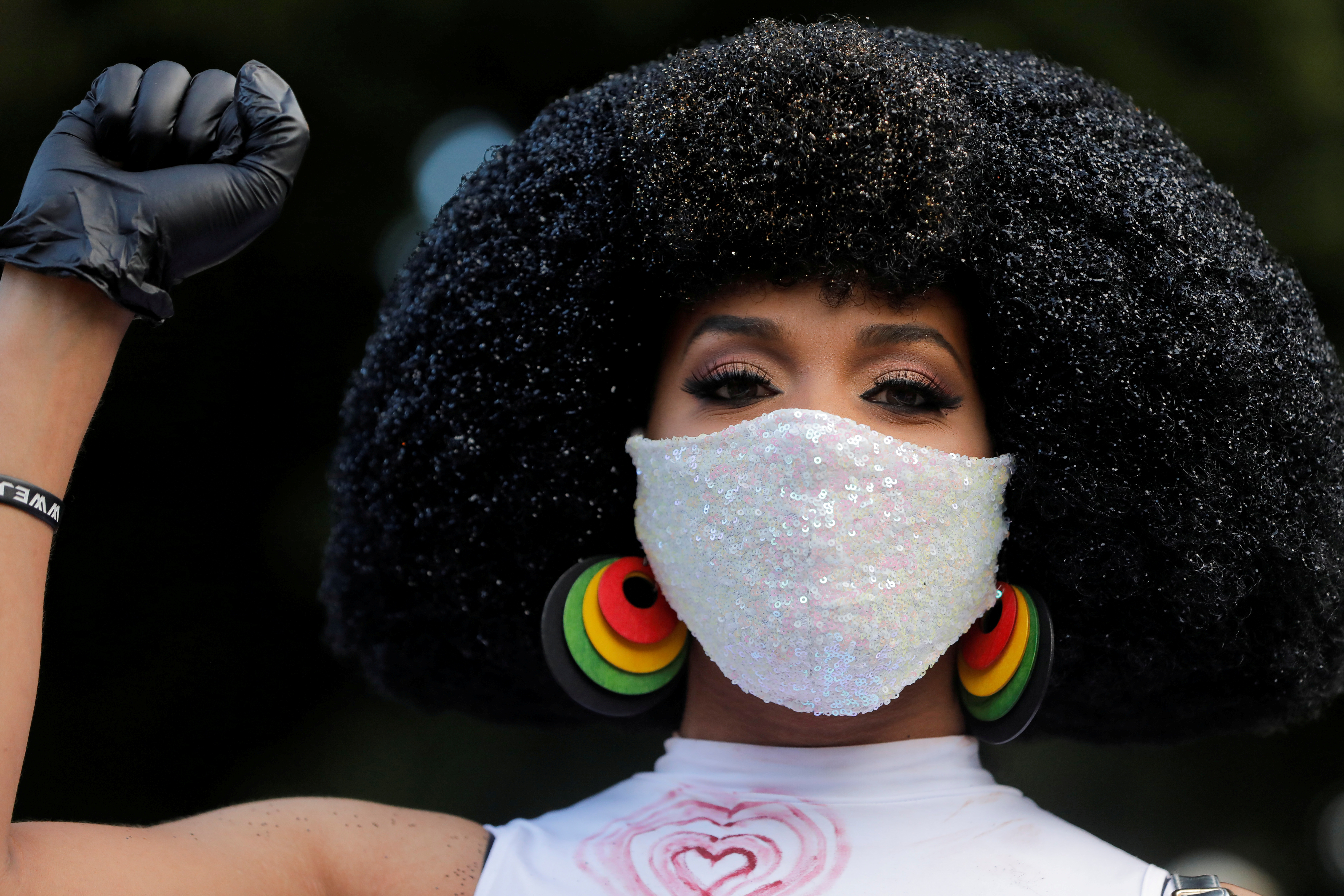A woman raises her fist during events to mark Juneteenth, which commemorates the end of slavery in Texas, two years after the 1863 Emancipation Proclamation freed slaves elsewhere in the United States, amid nationwide protests against racial inequality, in the Harlem neighbourhood of Manhattan, in New York City, New York, June 19, 2020 [Andrew Kelly/Reuters]