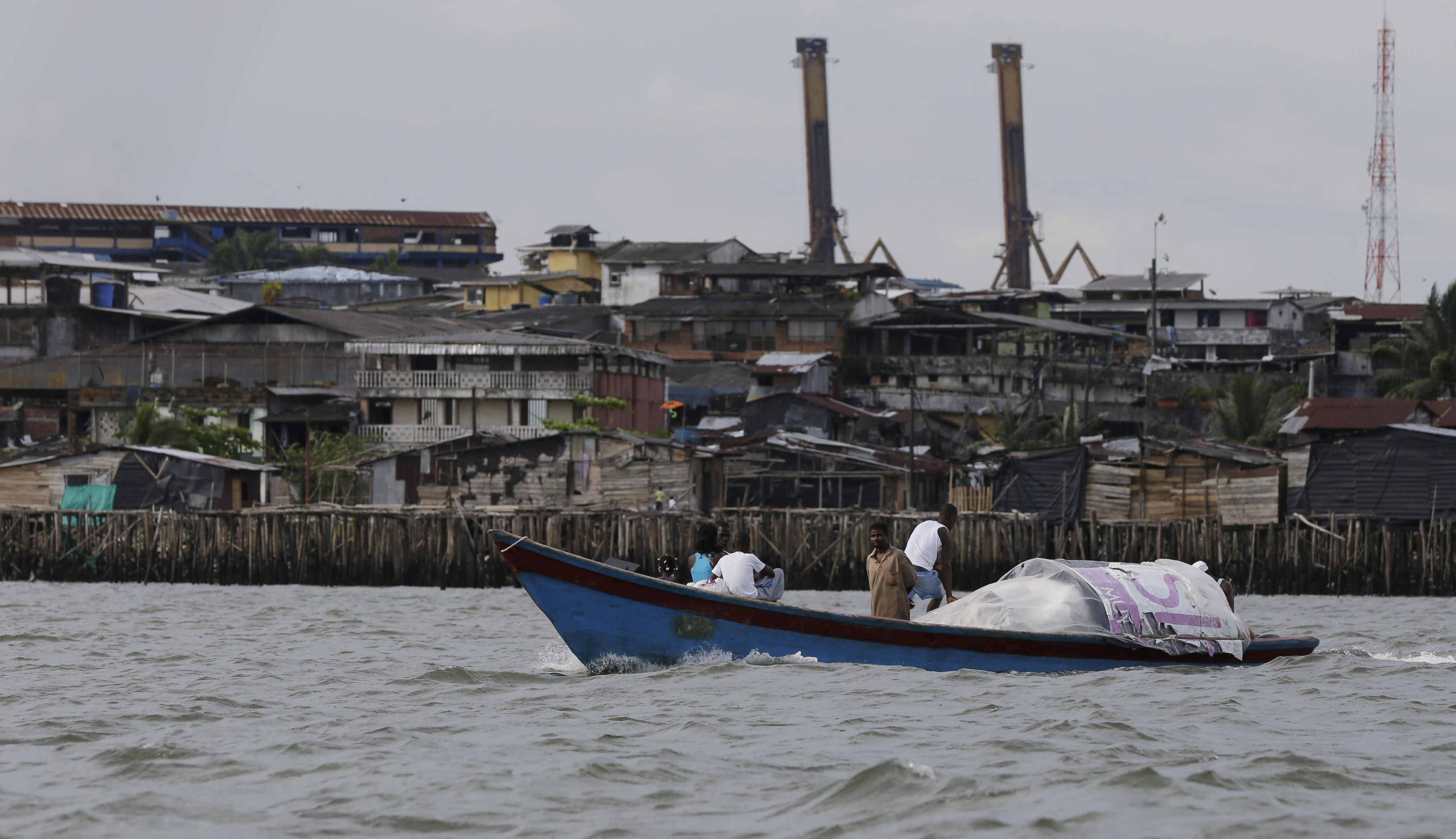 A boat cruises past Buenaventura, Colombia's main port city on the Pacific coast [File: Fernando Vergara/AP Photo]
