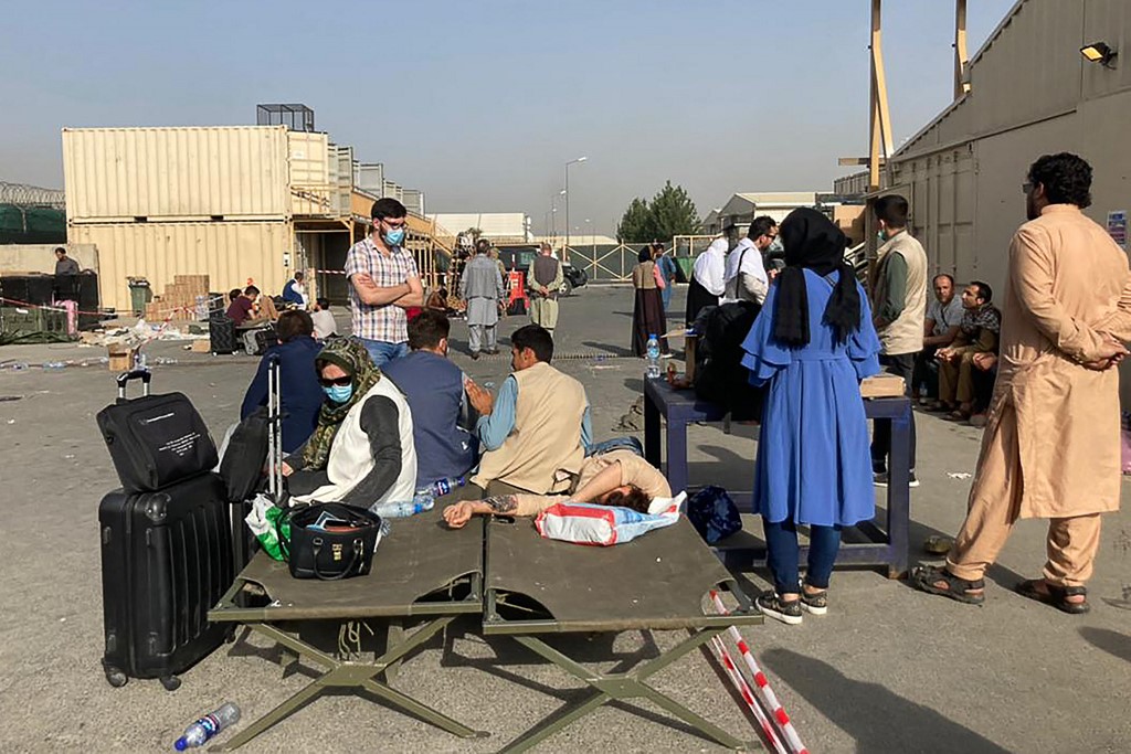 People wait to be evacuated from Afghanistan at the airport in Kabul [AFP]