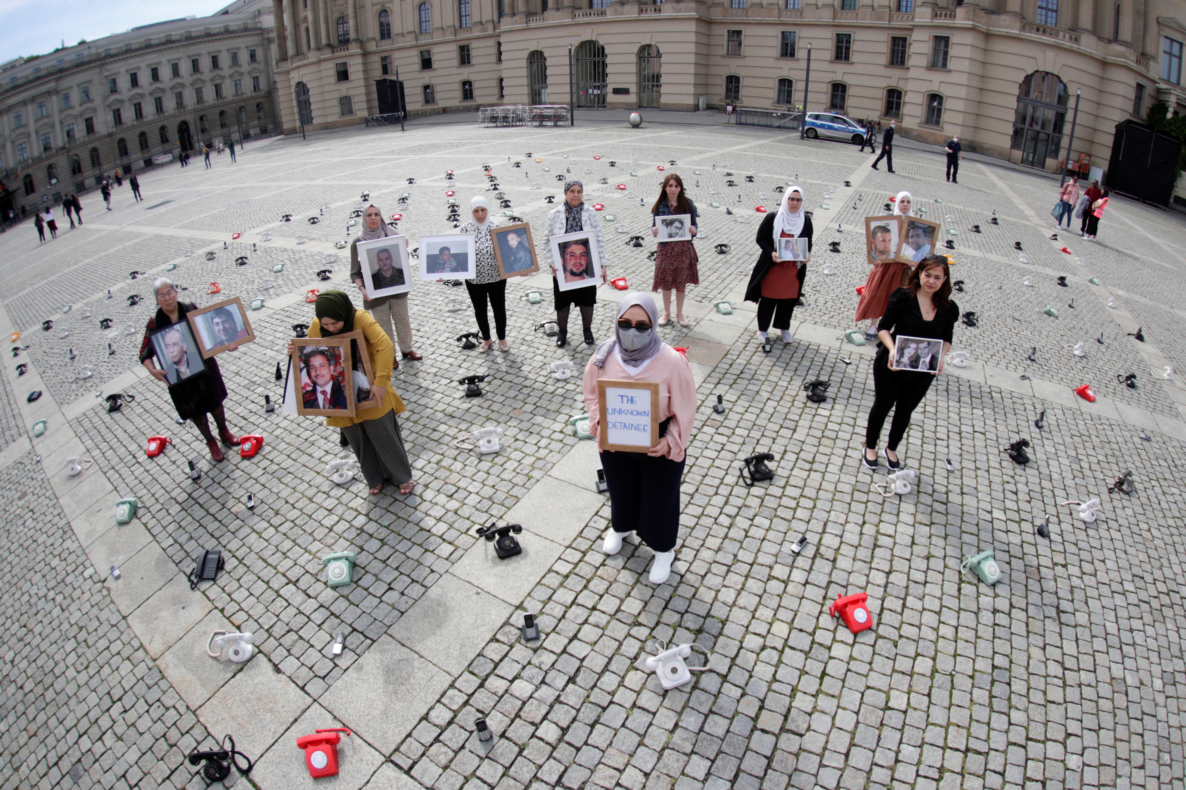 Syrians hold portraits of disappeared loved ones during a protest at the Bebelplatz to call on governments to do more to seek information about prisoners in Syria, in Berlin on August 28, 2021 [Hannibal Hanschke/Reuters]
