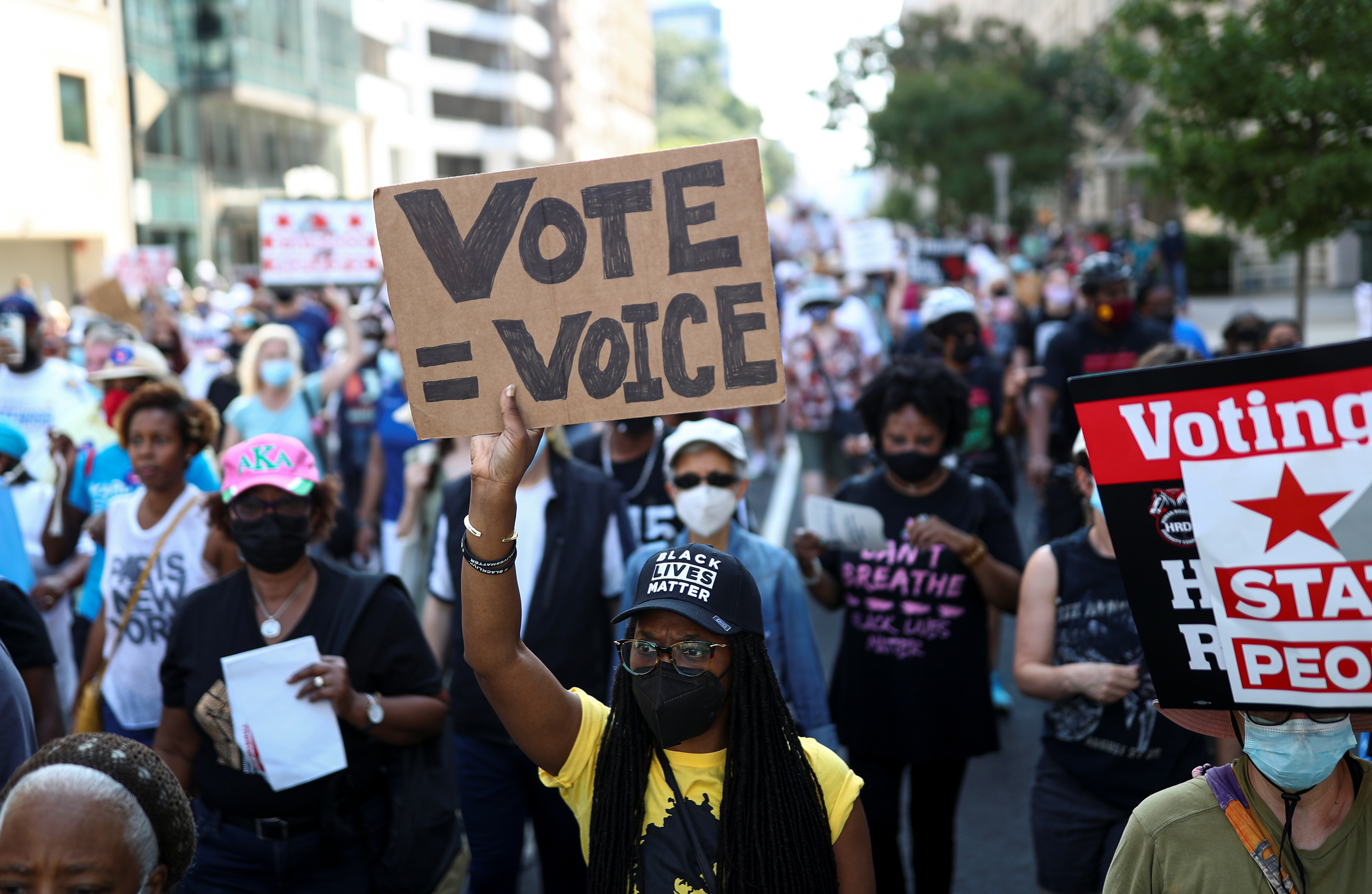 Protestors hold signs calling demanding protection for voting rights