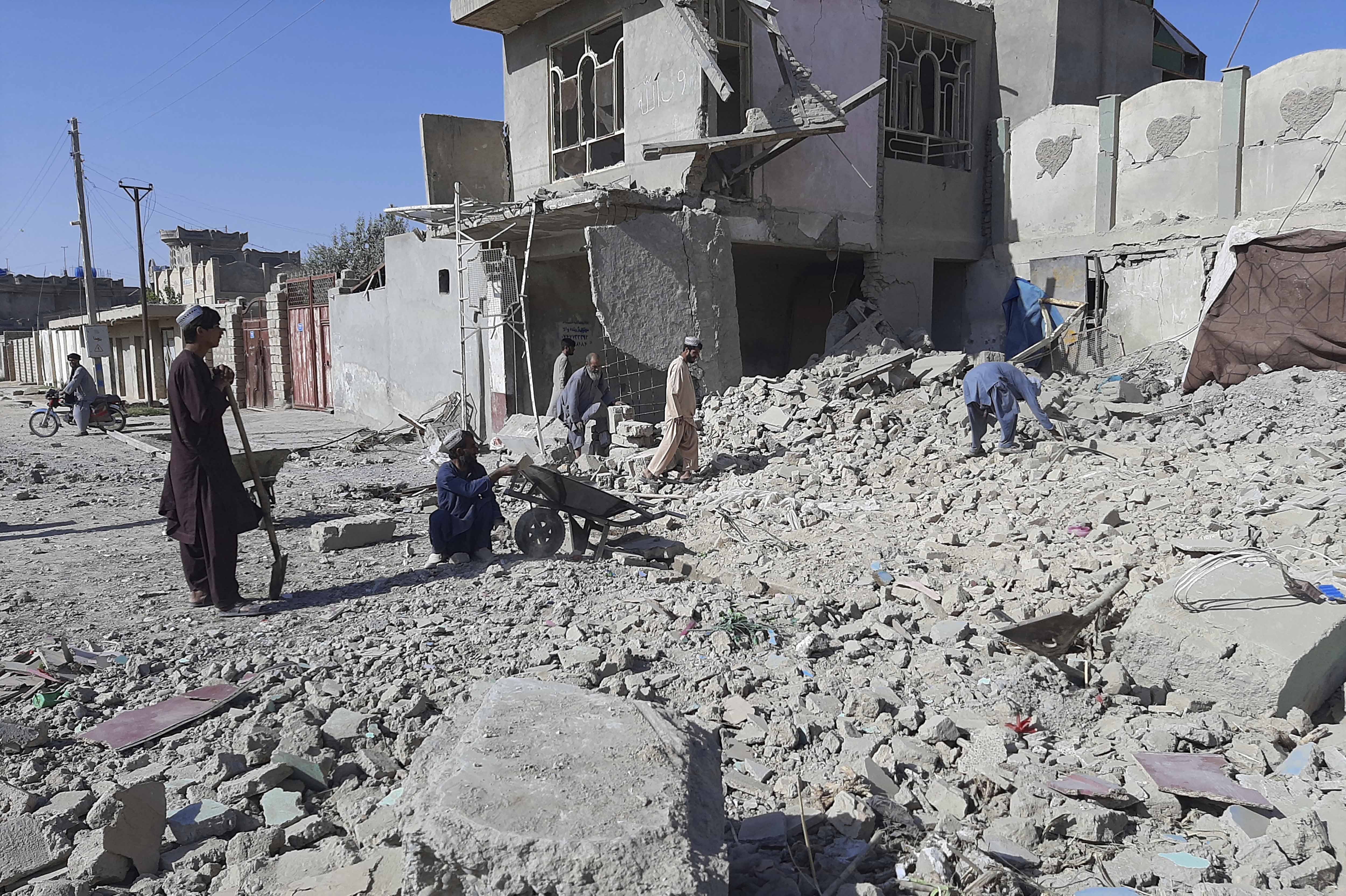 Afghans inspect a damaged building after air attacks in Lashkar Gah, Helmand province where the attacks damaged a healthcare clinic and high school in Lashkar Gah, a provincial council member said [AP/Abdul Khaliq]