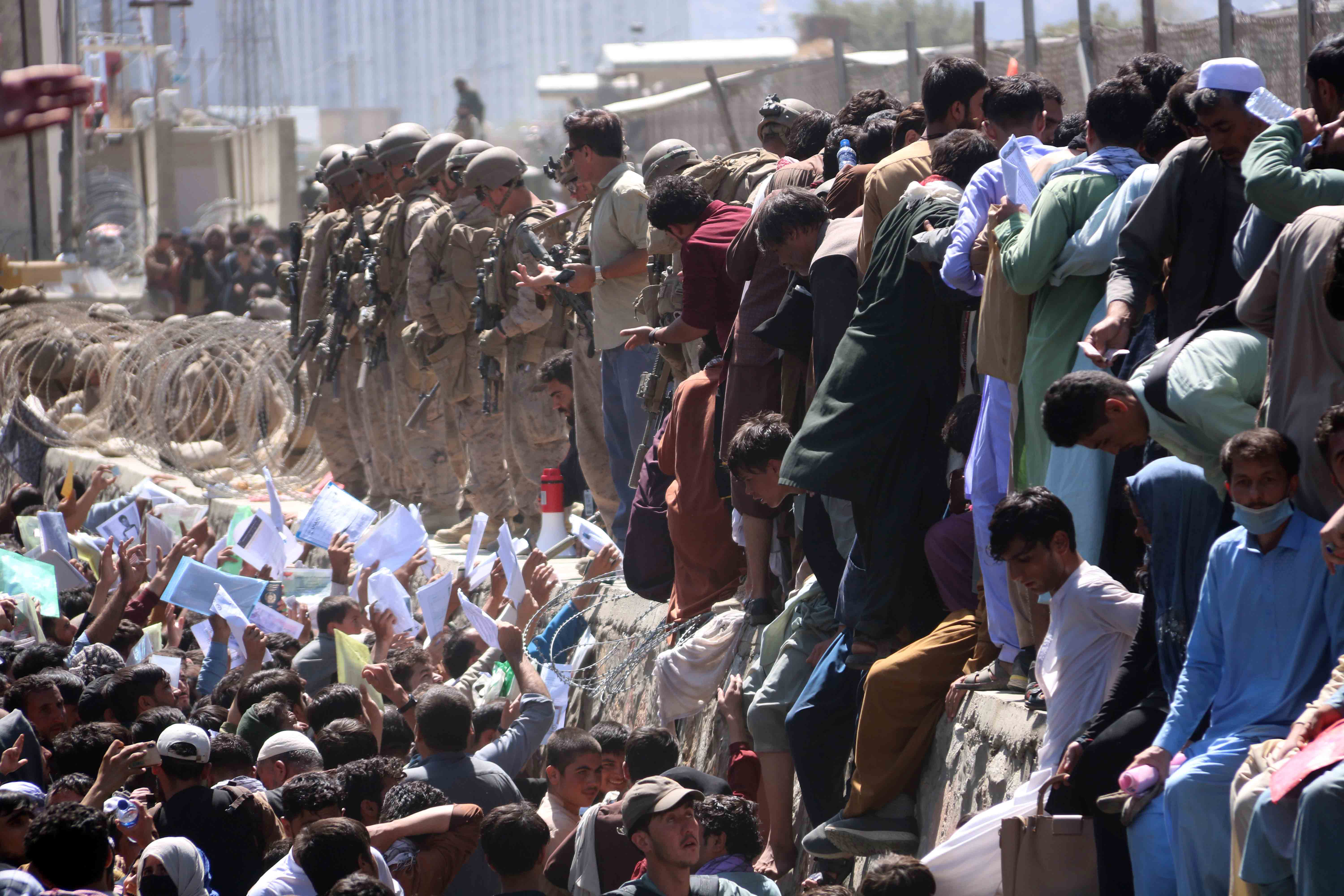 Afghans struggle to reach the foreign forces to show their credentials to flee the country outside the Hamid Karzai International Airport, in Kabul, Afghanistan, 26 August 2021. [Akhter Gulfam/EPA]