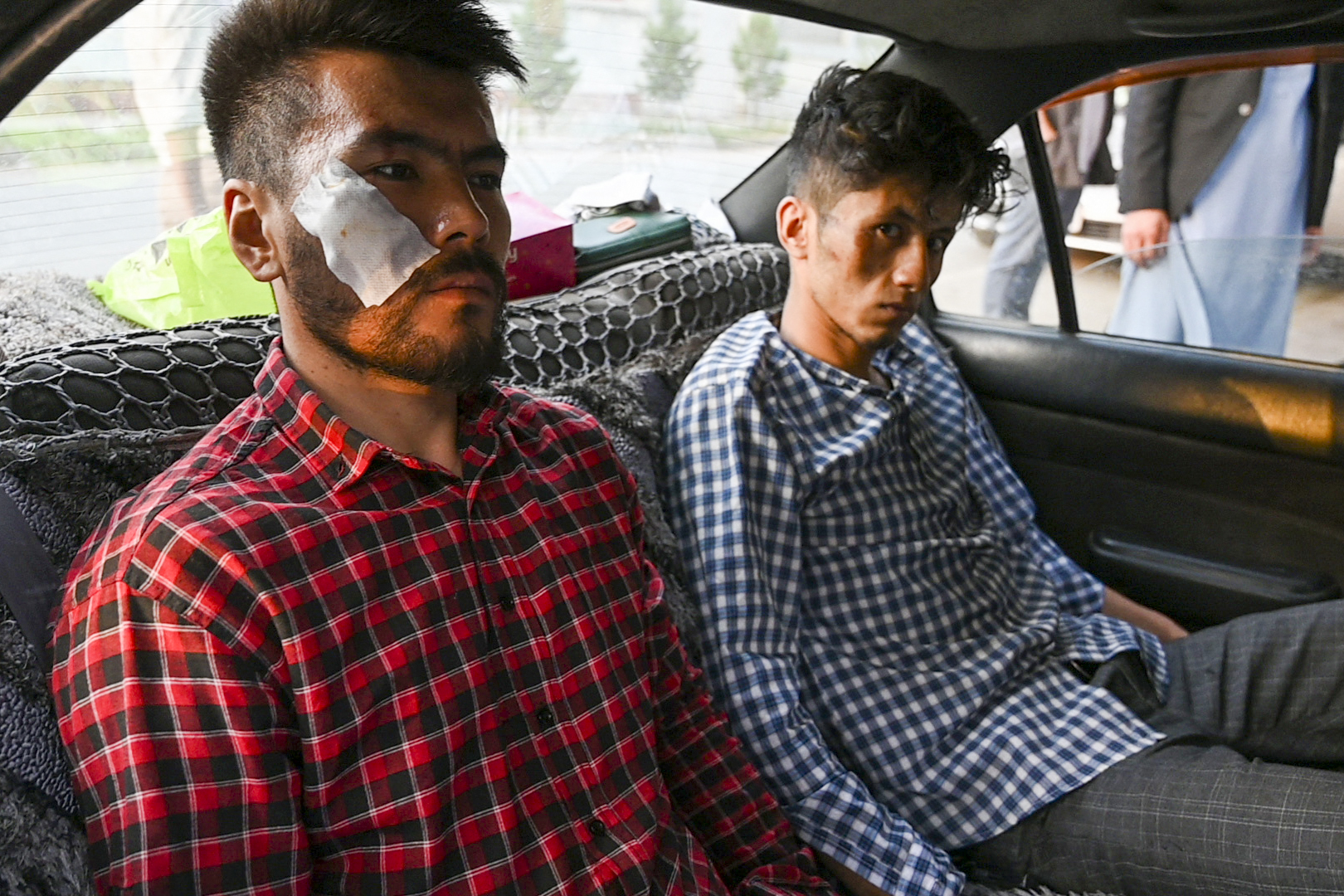 Afghan journalists Nematullah Naqdi. left, and Taqi Daryabi arrive at their newspaper office after being released from Taliban custody, in Kabul [File: Wakil Kohsar/AFP]