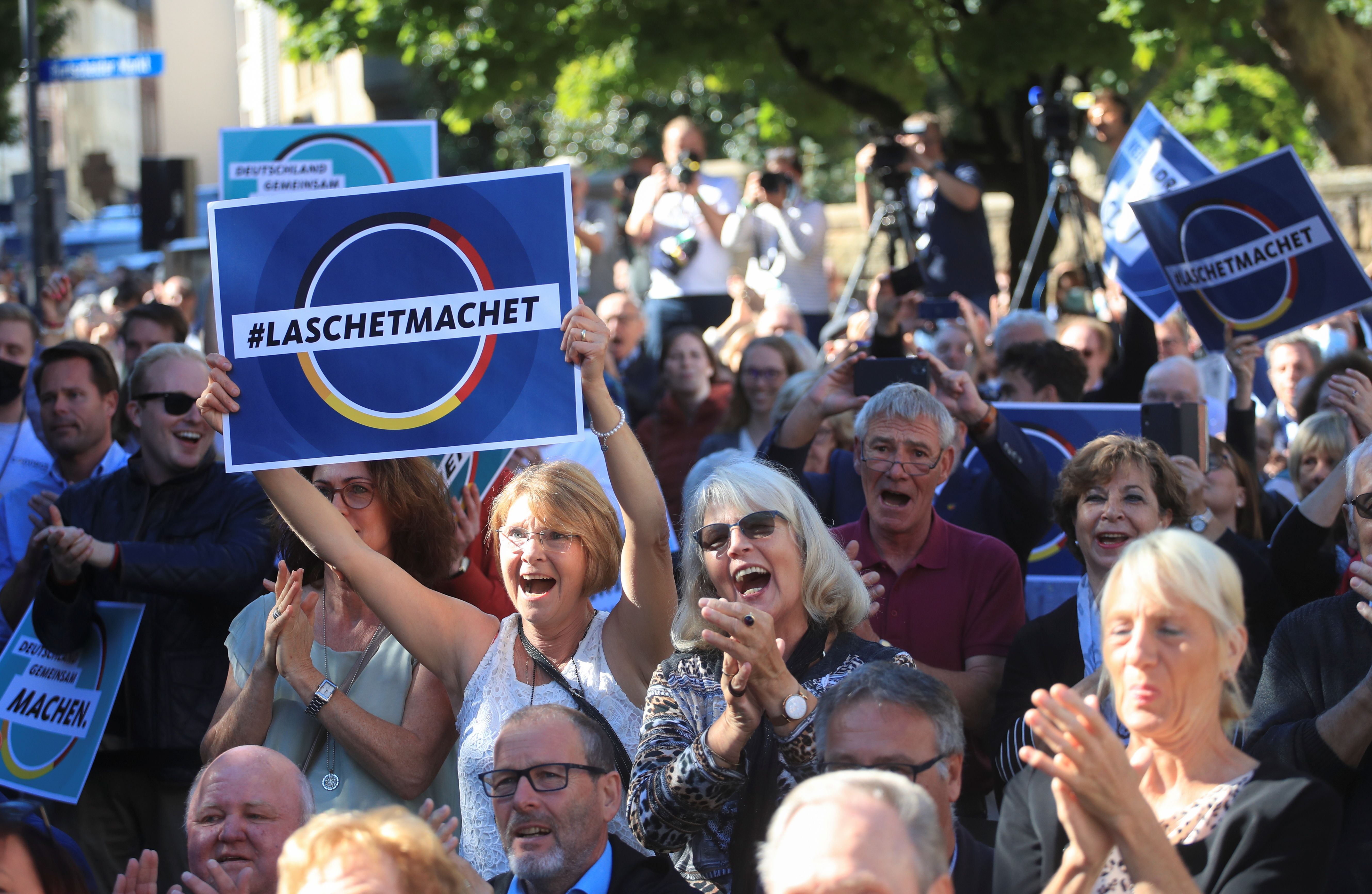 People take part in a rally with German Chancellor Angela Merkel and candidate for chancellor Armin Laschet [File: Reuters]