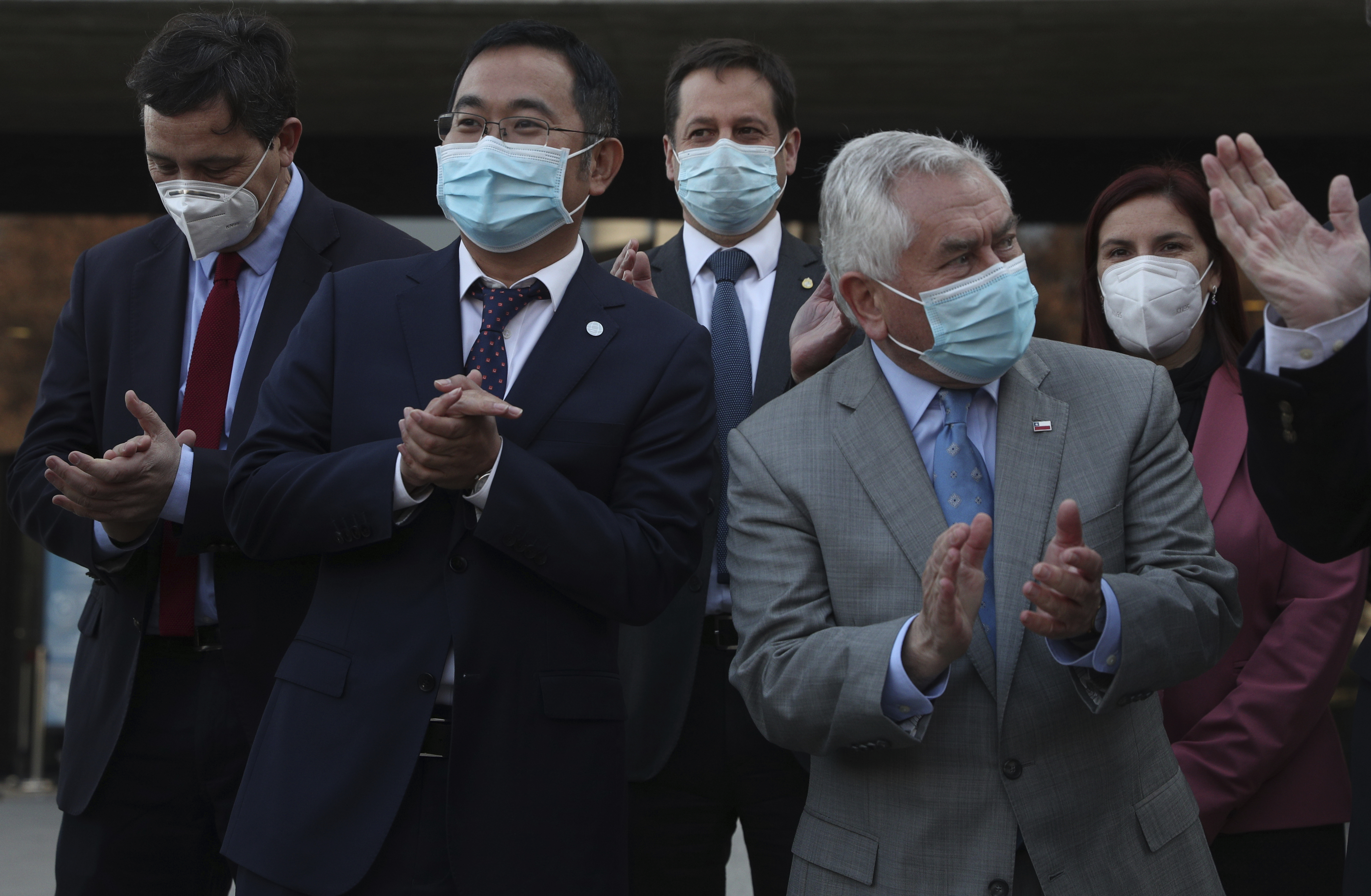 Meng Weining, vice president of Chinese pharmaceutical firm Sinovac (left) and Chile's Health Minister Enrique Paris (right) celebrated the announcement last month that Sinovac would invest in building a COVID-19 vaccine production plant in Chile as well as an investigation centre for respiratory viruses [File: Esteban Felix/AP Photo]