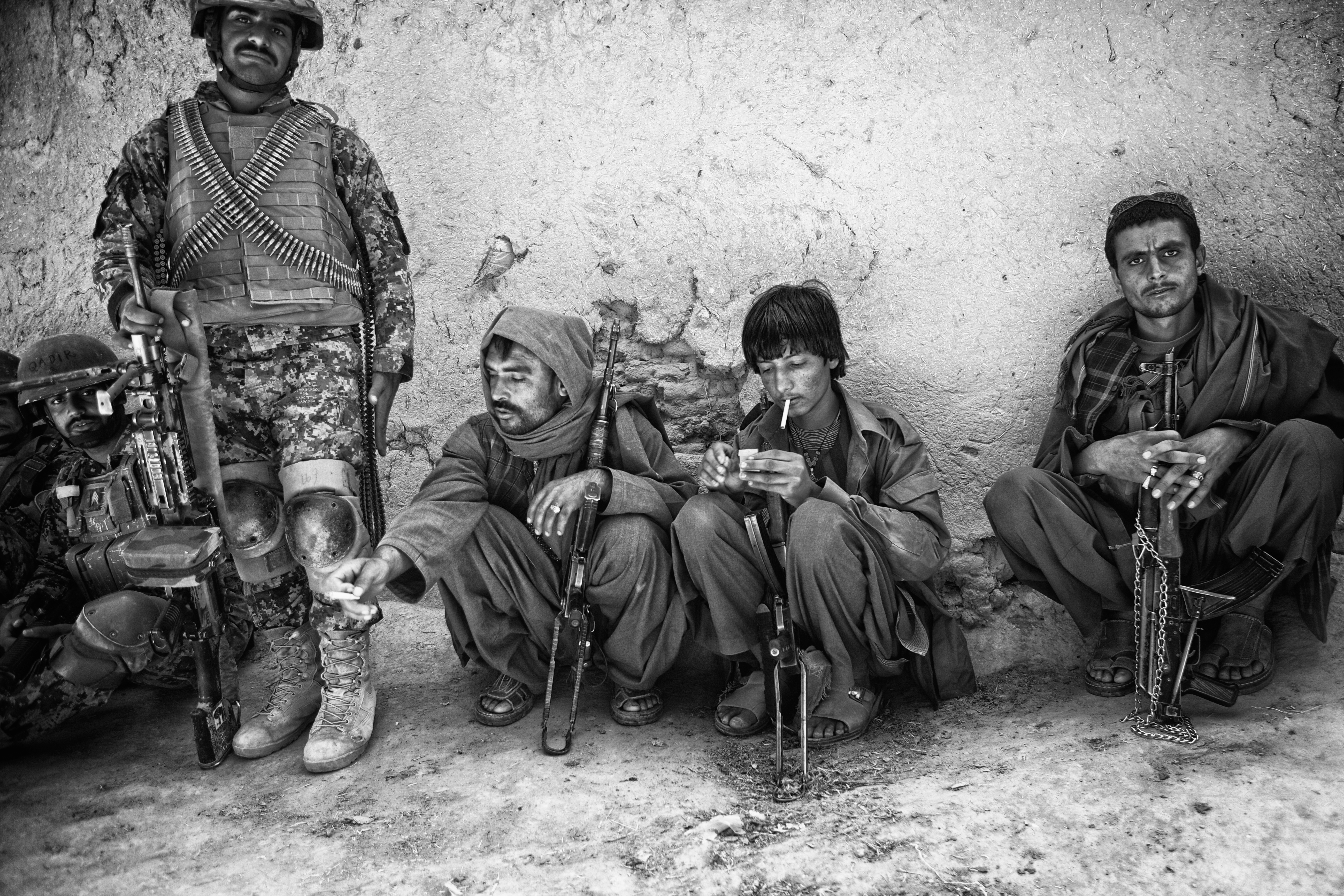 Abdul Jalil, an Afghan local police commander, third from left, is seen alongside other fighters during a short lull in a five-hour firefight with the Taliban in Pay-E Moluk village, Panjwayi district, Kandahar, on April 30, 2013. Jalil was killed fighting the Taliban days after this photo was taken [John D McHugh/Al Jazeera]