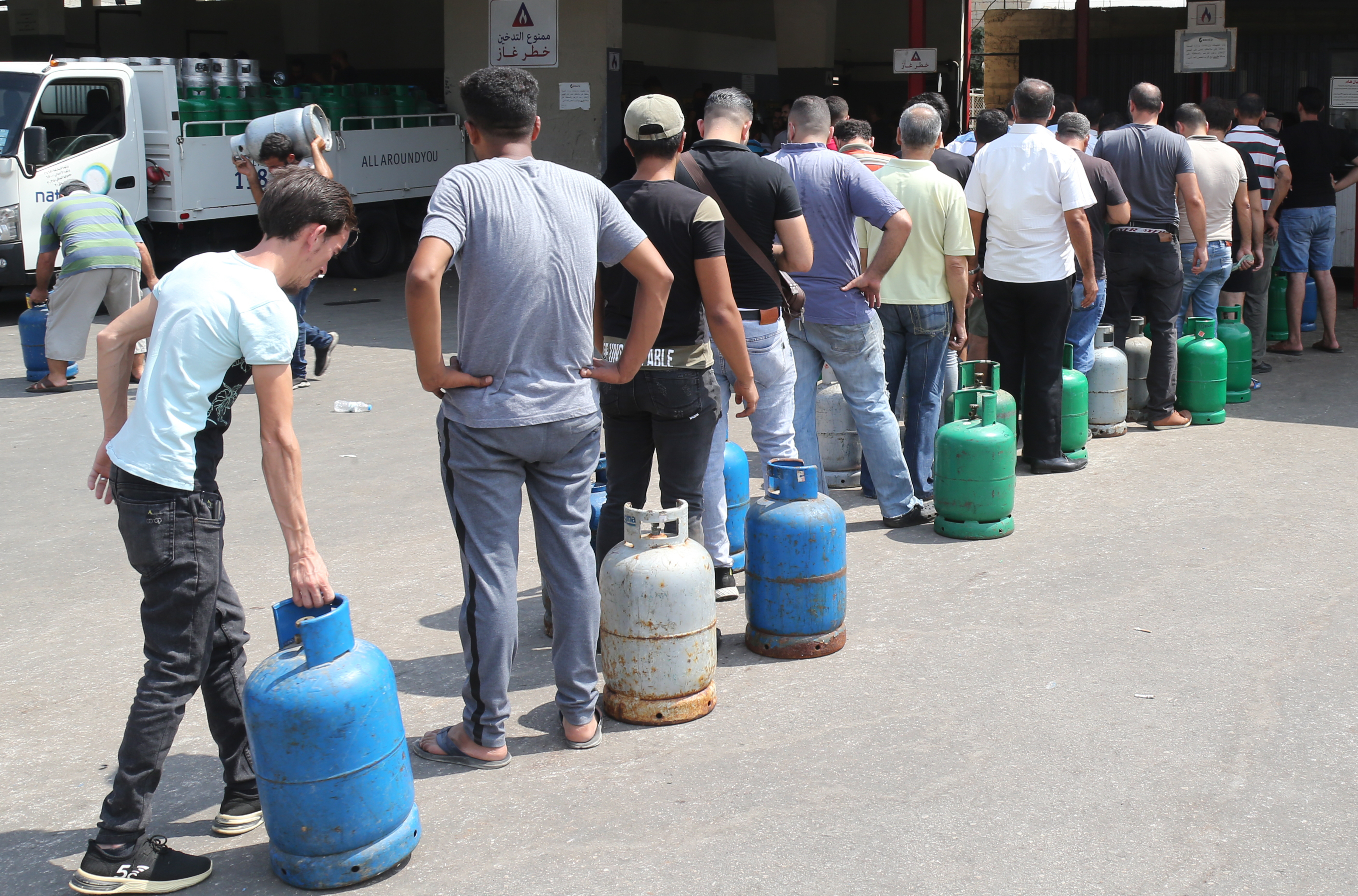 People queue to refill domestic gas cylinders at a petrol station in the Ouzai area of the capital Beirut [Nabil Mounzer/EPA-EFE]