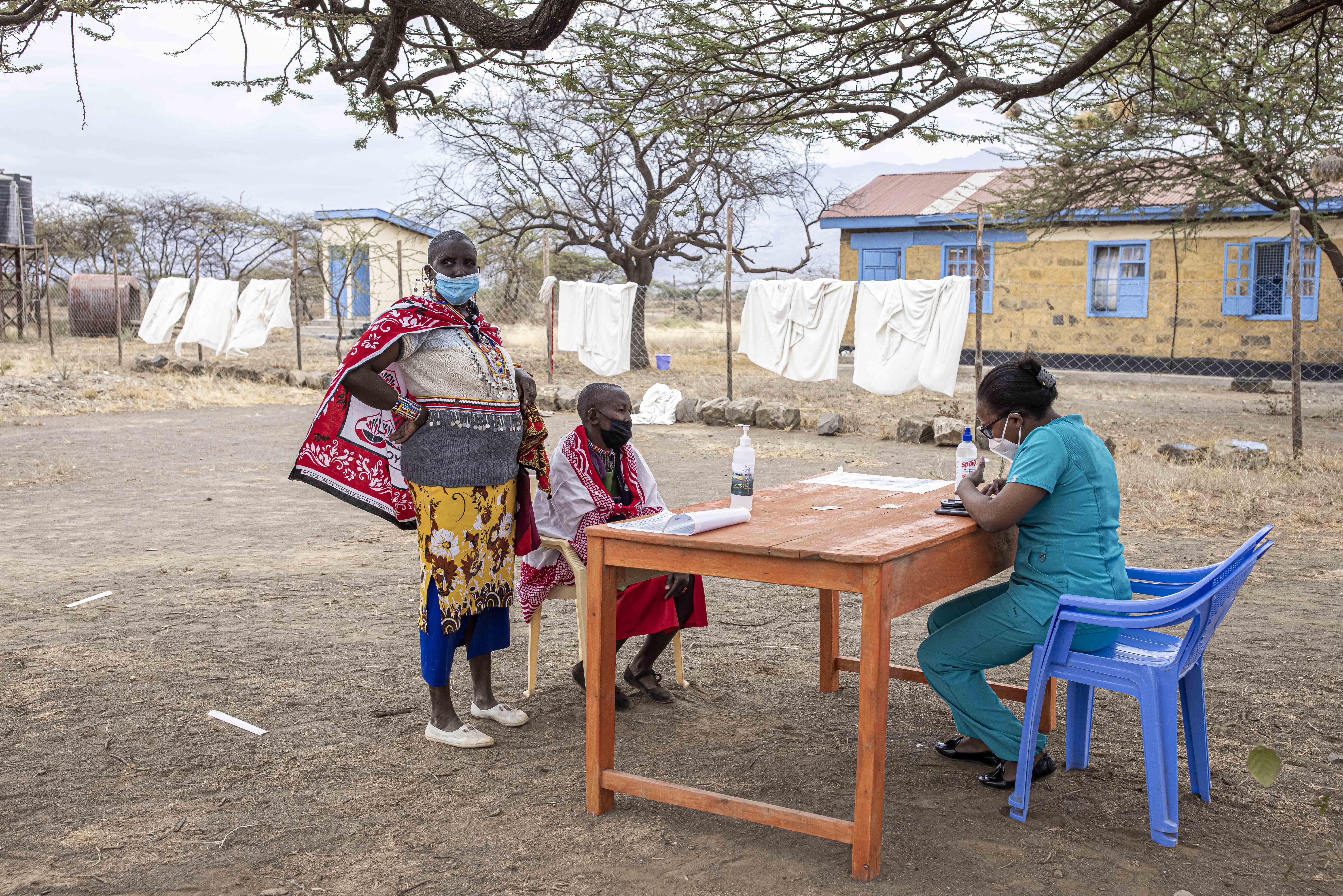 Two Maasai women register for the COVID-19 vaccine at Oltepesi Dispensary in Kajiado, Kenya, on September 9, 2021 [Patrick Meinhardt/AFP]