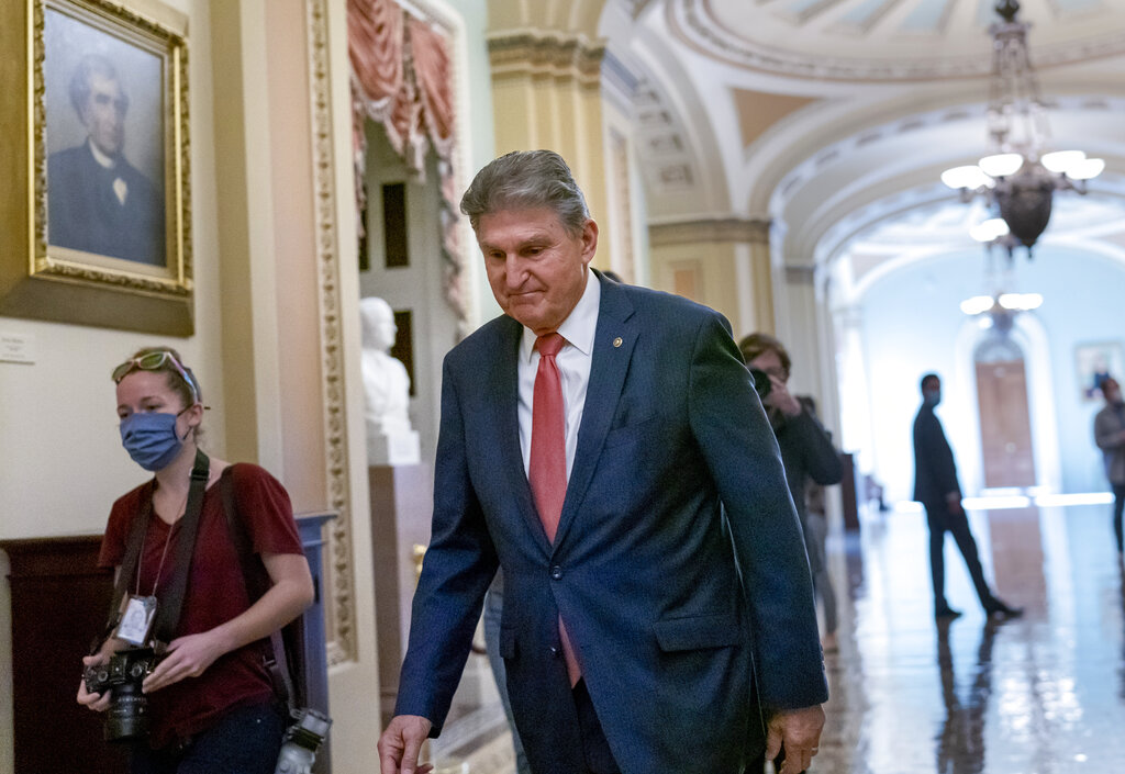 Senator Joe Manchin, a centrist Democrat vital to the fate of President Joe Biden's $1.75 trillion spending plan walks alone to a Democratic caucus lunch at the Capitol