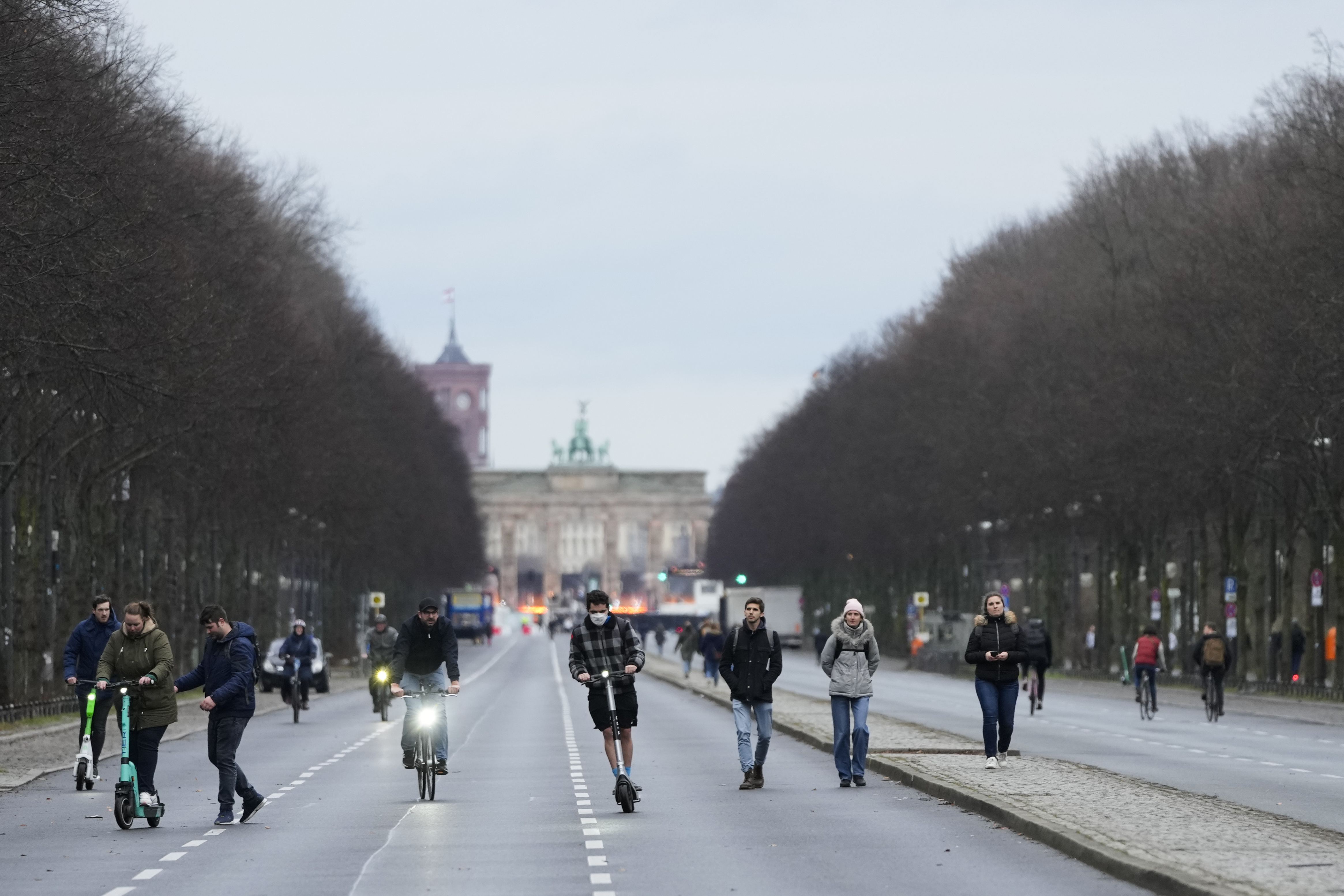 A few people walk on the boulevard 'Strasse des 17. Juni' in front of the Brandenburg Gate Berlin, Germany