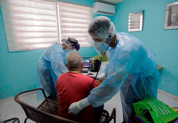 Paramedics treat a man with respiratory distress, using a stethoscope to listen to his lungs