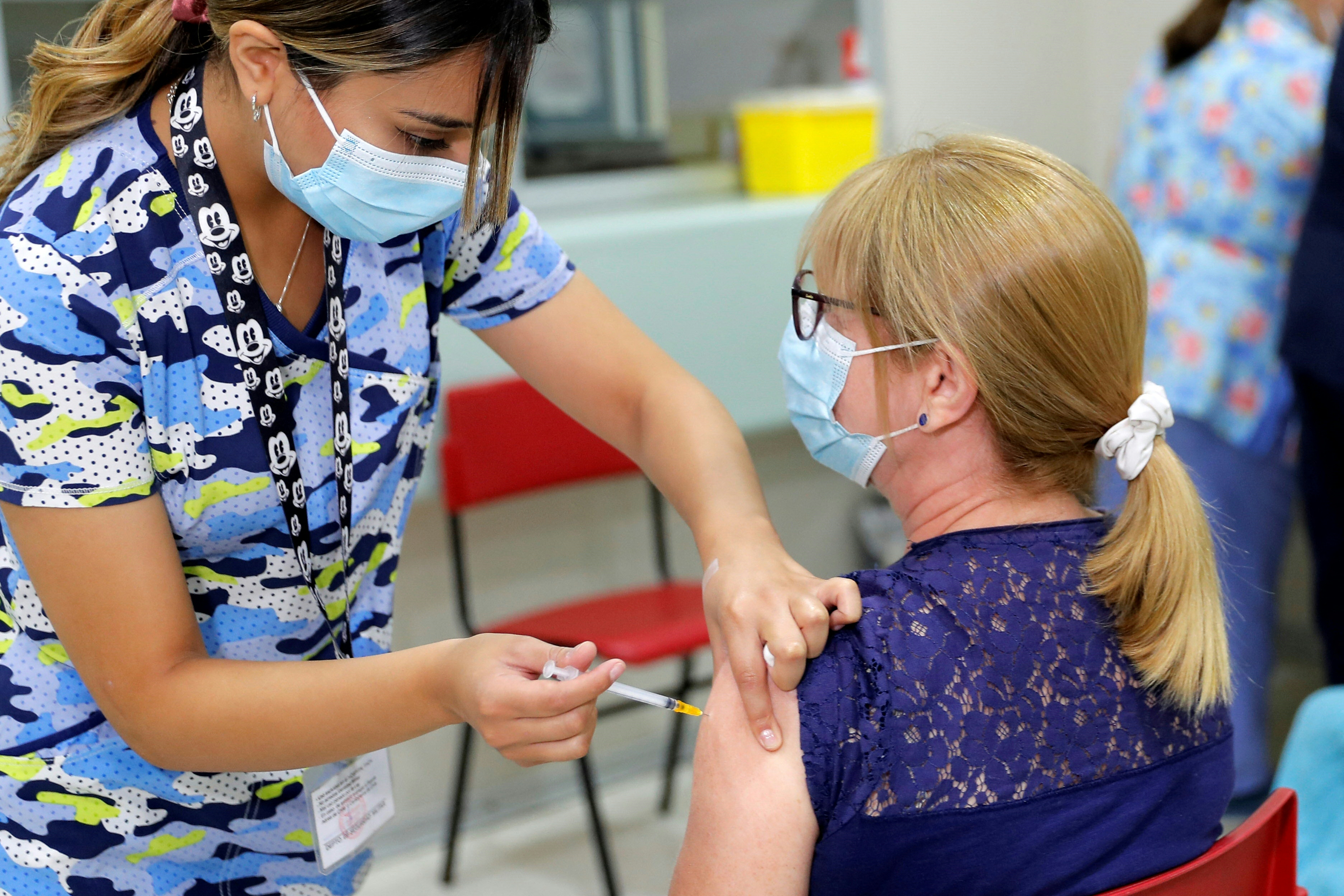 A woman receives a dose of the Pfizer-BioNTech vaccine against the coronavirus disease COVID-19