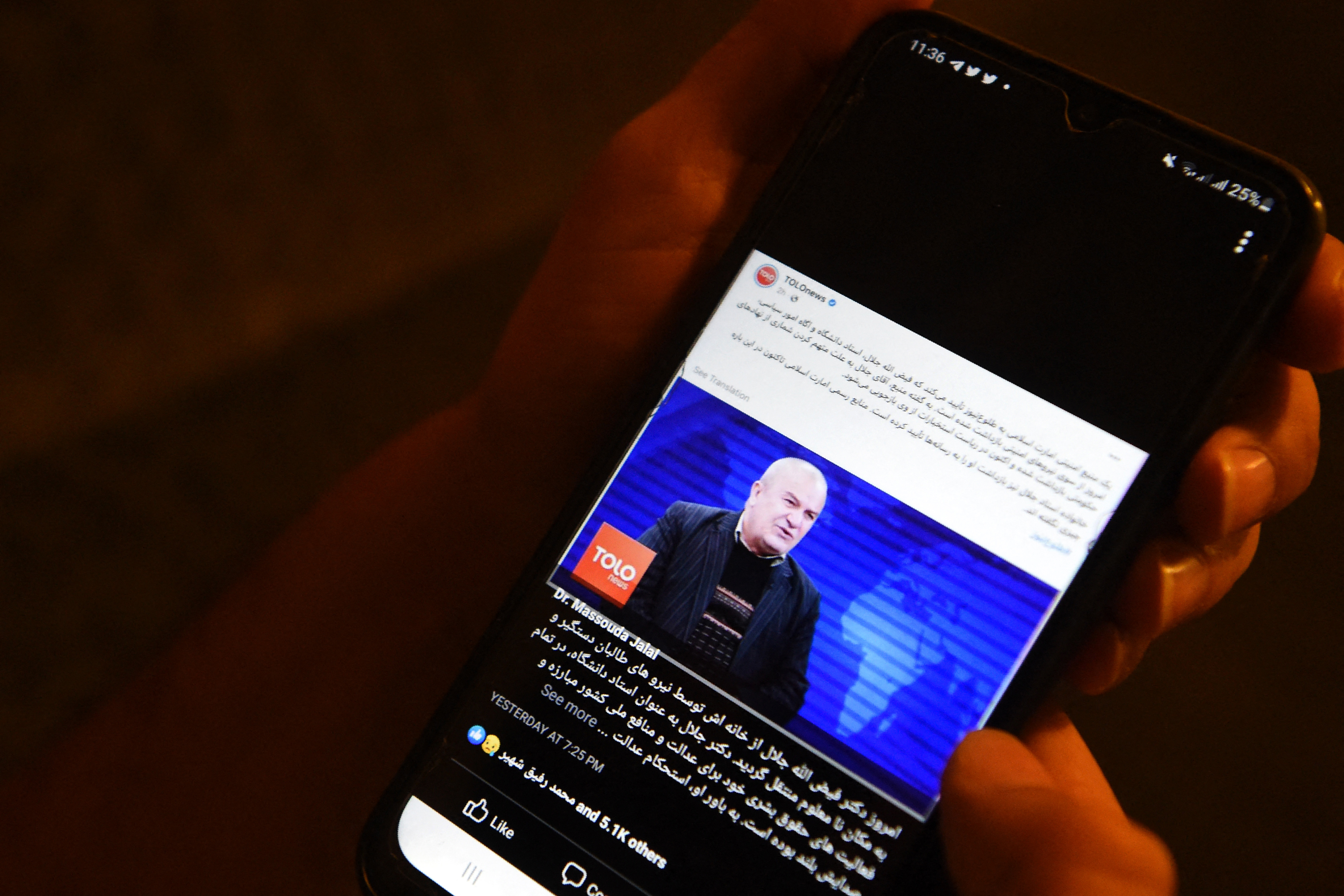 A man uses his mobile phone to read news reporting on the arrest of prominent Afghan university professor
