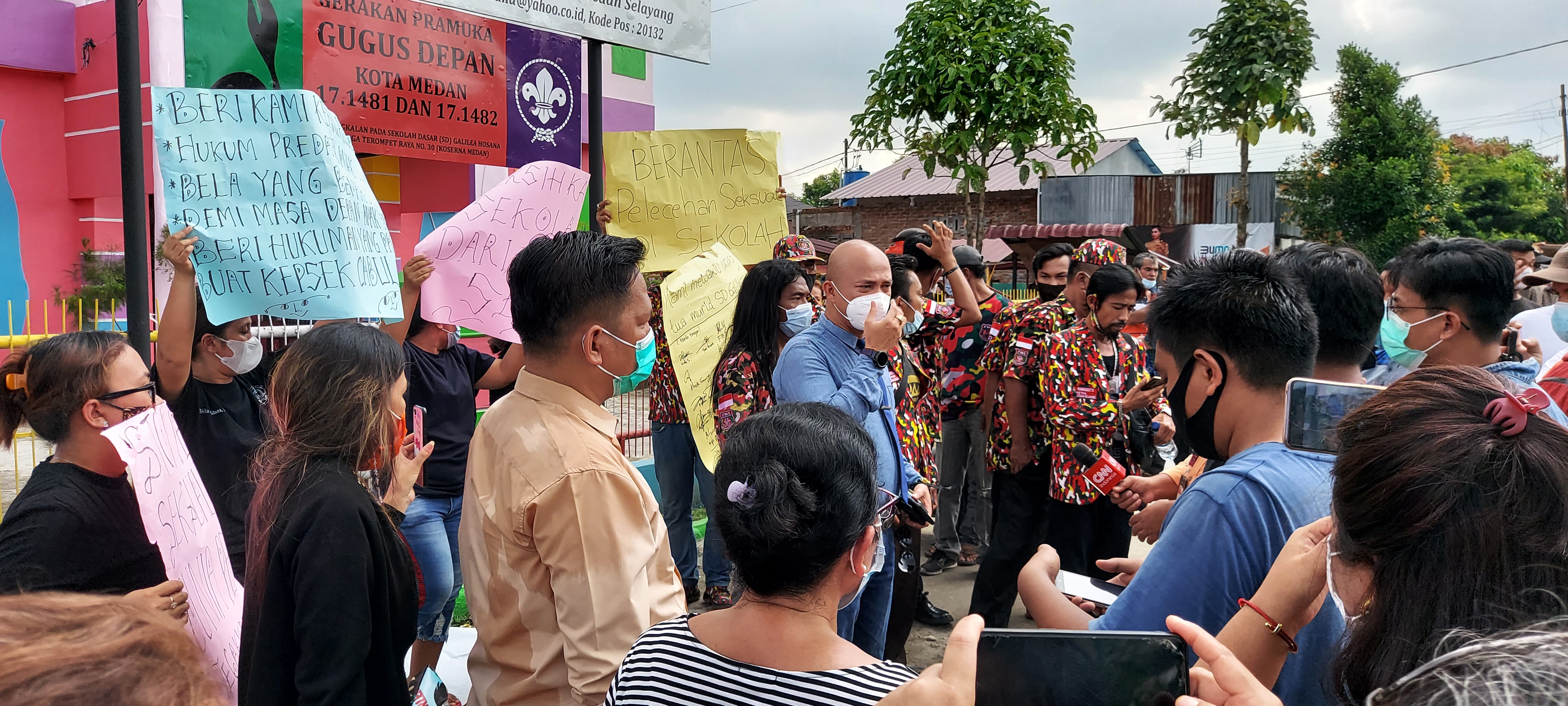 A group of parents hold a protest outside the Galilea Hosana School in Medan after a priest was accused of sexually assaulting some of the young girls attending the institution