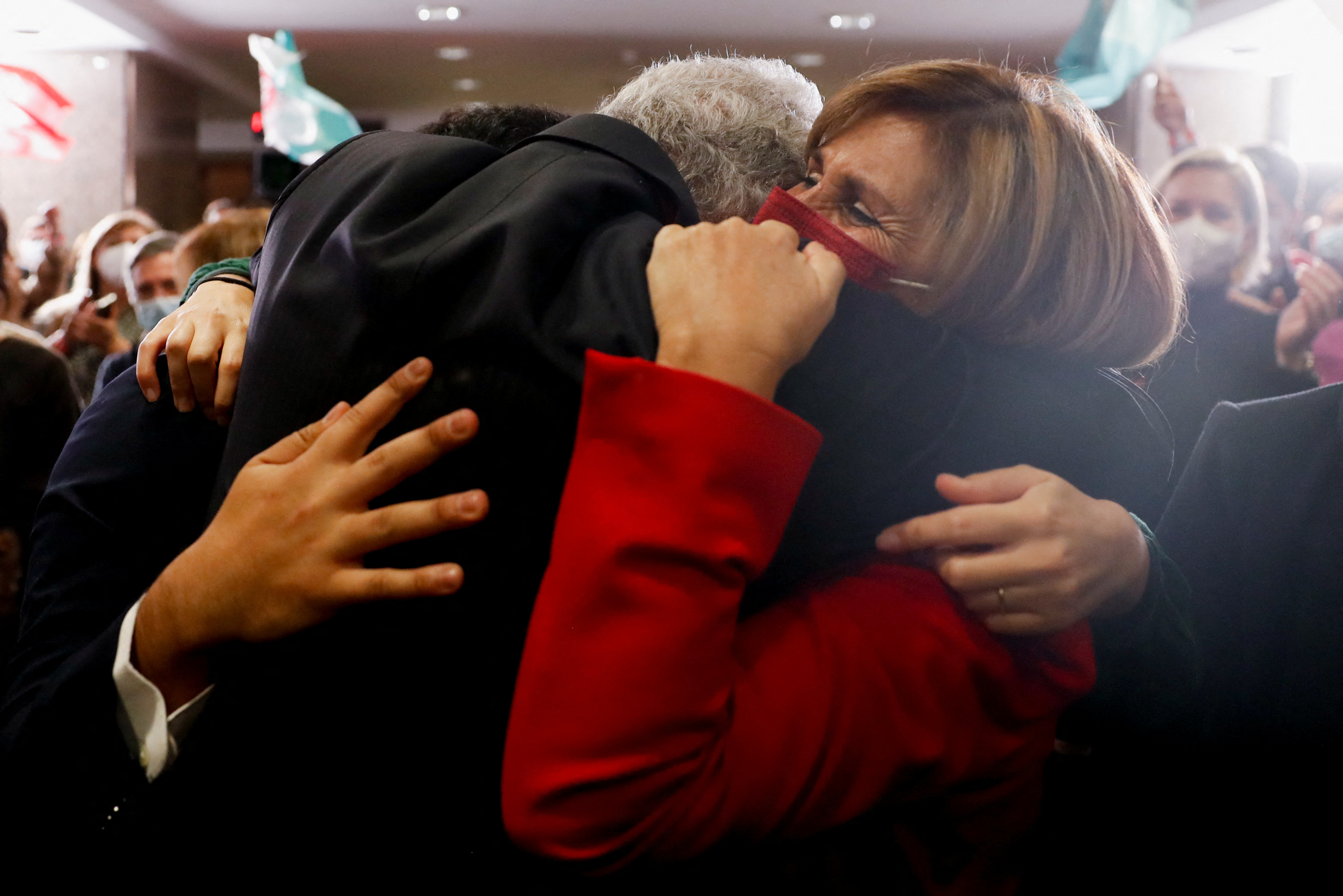 Portugal's prime minister, with his back to the camera, hugs his wife who's wearing a red coat after winning the snap election