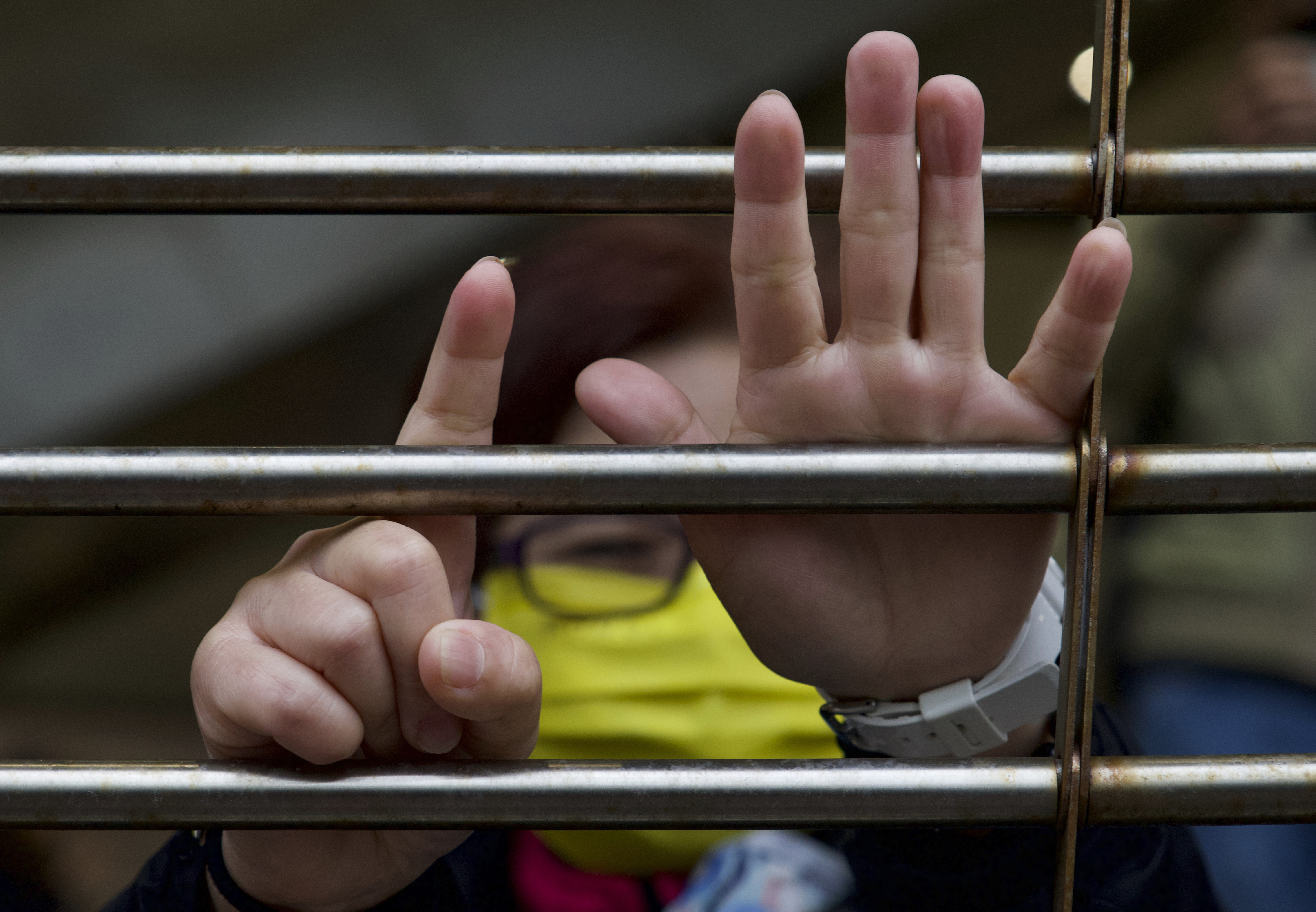 A supporter gestures with their hands to signify the "Five demands - not one less", outside a court in Hong Kong