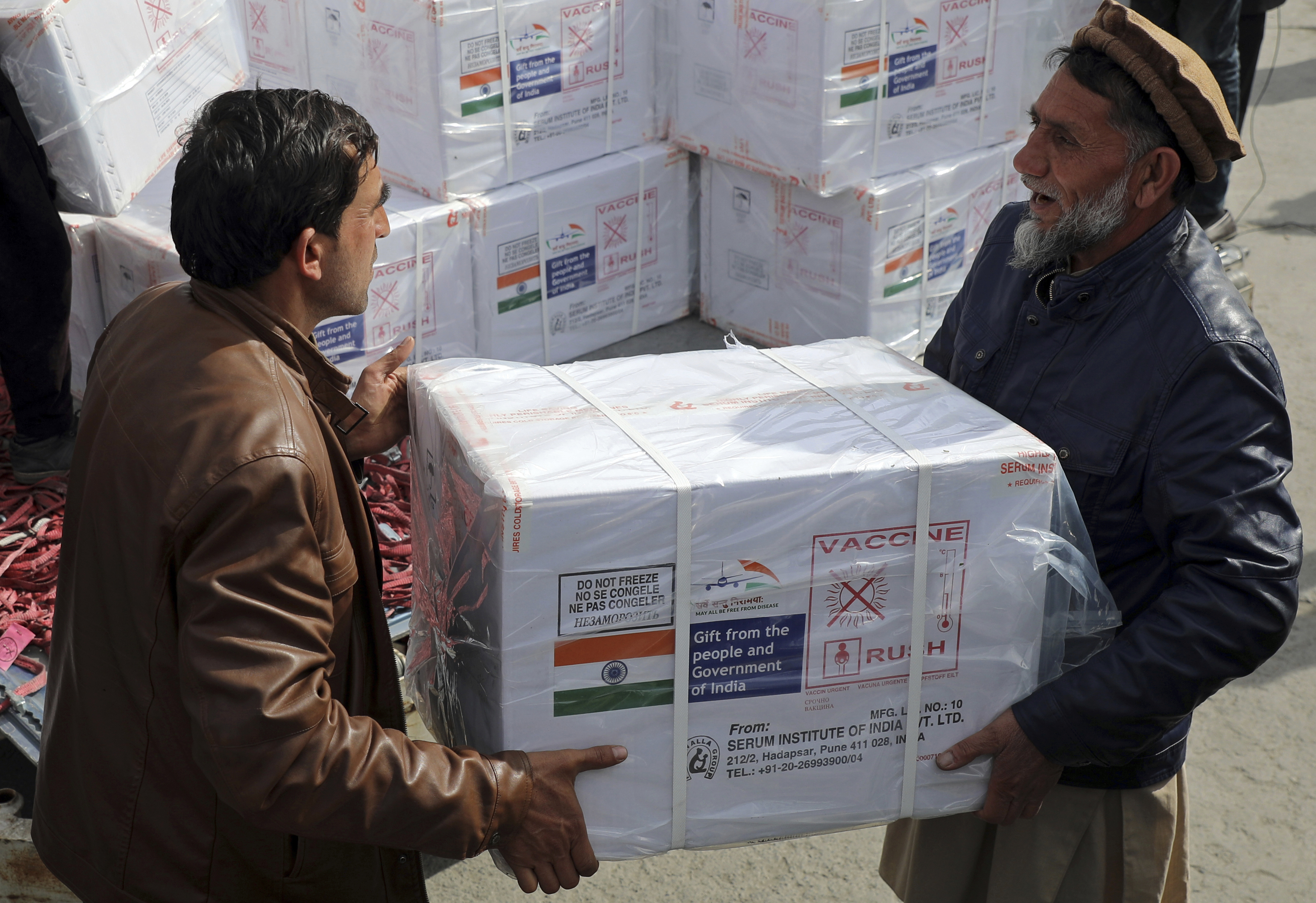 Afghan health ministry workers unloads boxes of the first shipment of 500,000 doses of the AstraZeneca coronavirus vaccine