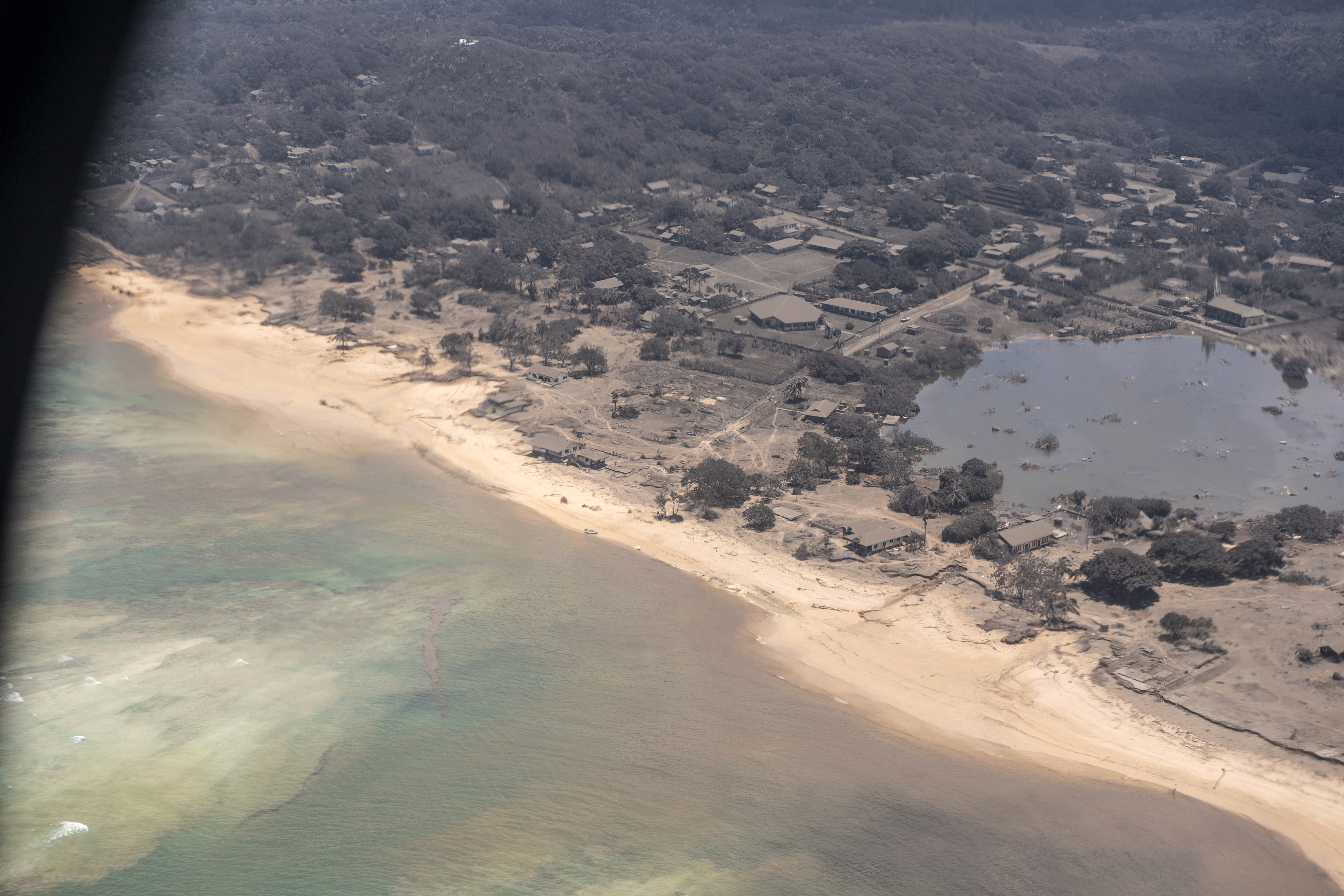 Ash covered homes and vegetation over Nomuka in Tonga