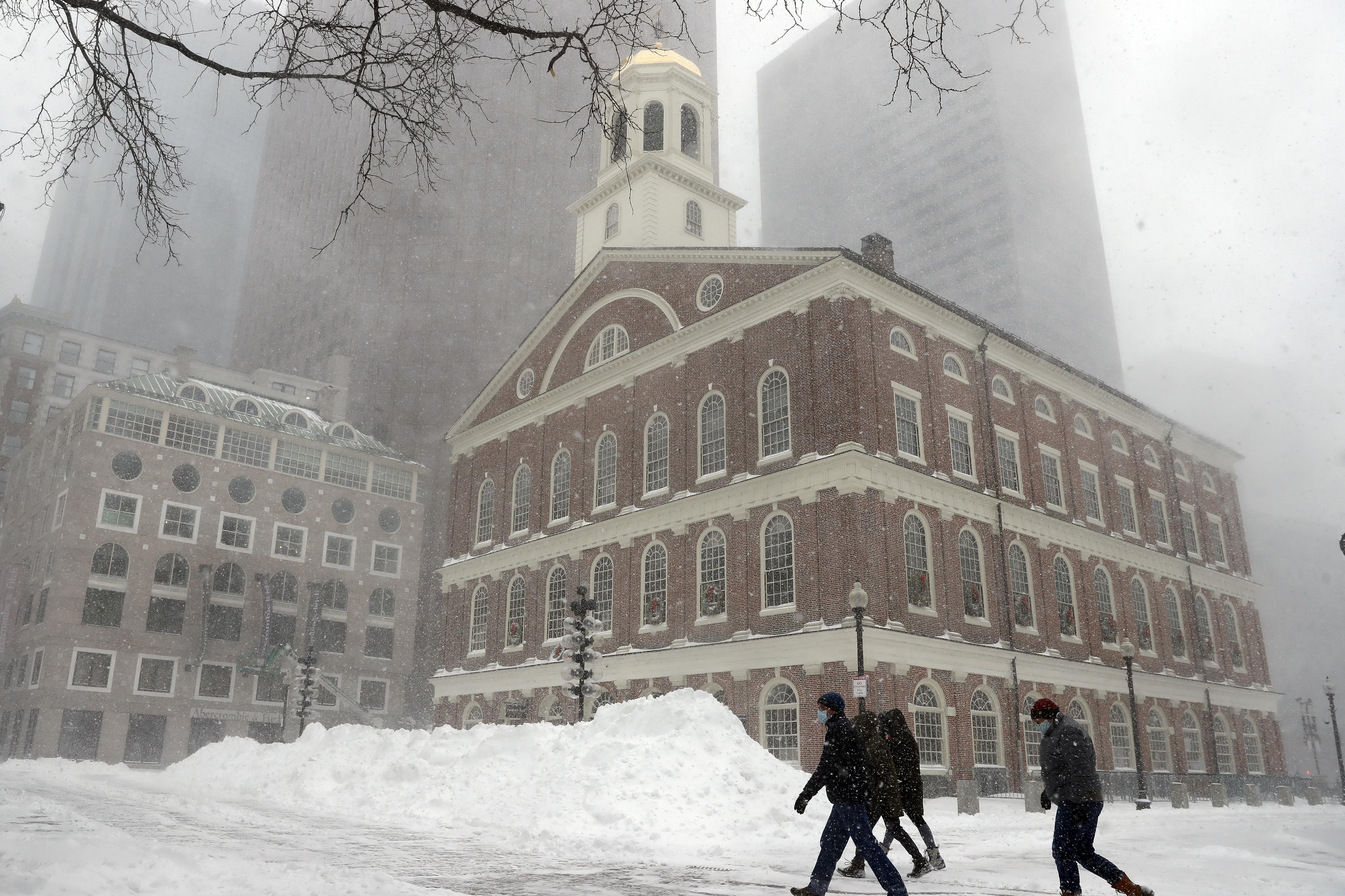 People walk in the snow outside Faneuil Hall,