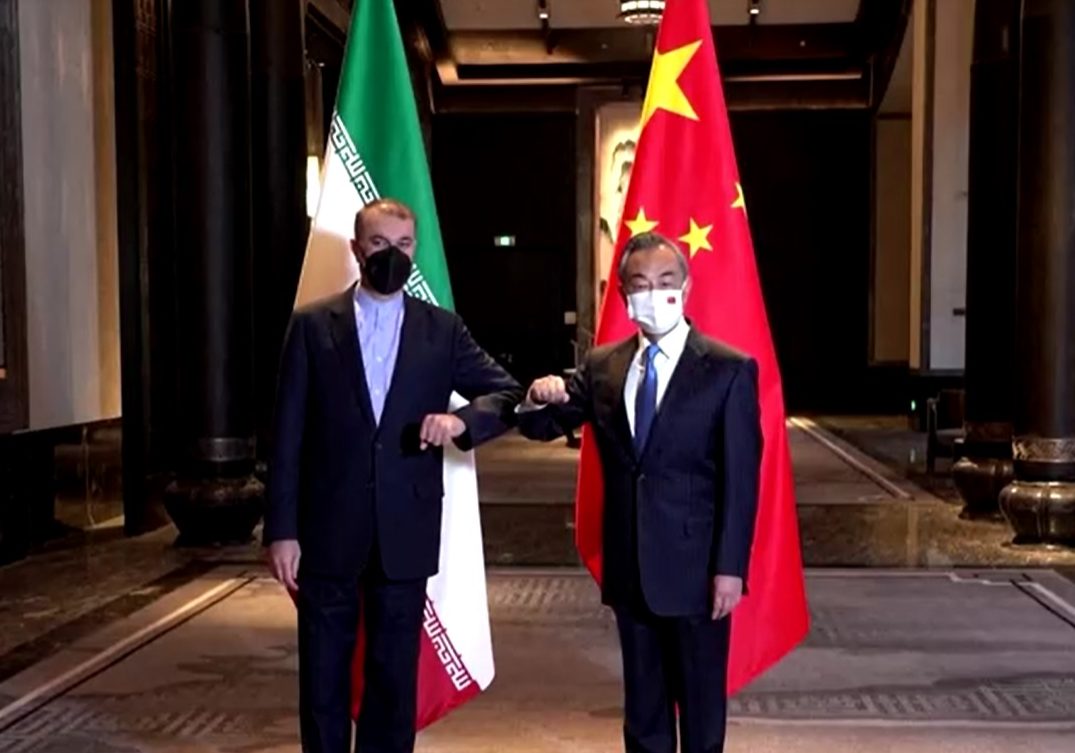 Chinese Foreign Minister Wang Yi stands with his Iranian counterpart Hossein Amirabdollahian (left) in front of their countries' flags during a meeting in Wuxi, in Jiangsu province.