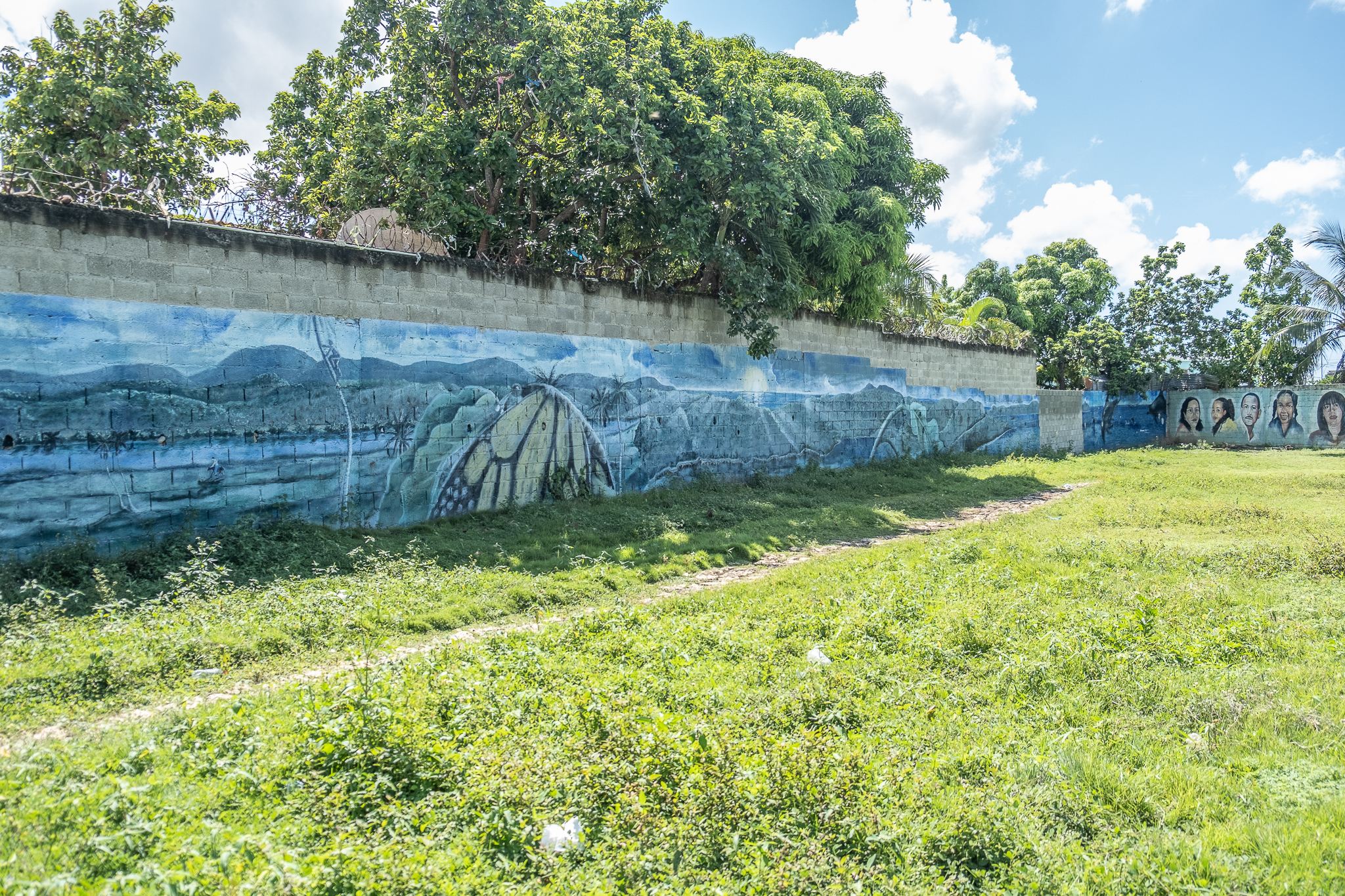 A wall of a park in Bajos de Haina with murals depicting activists and children from the neighbourhood of Paraiso de Dios