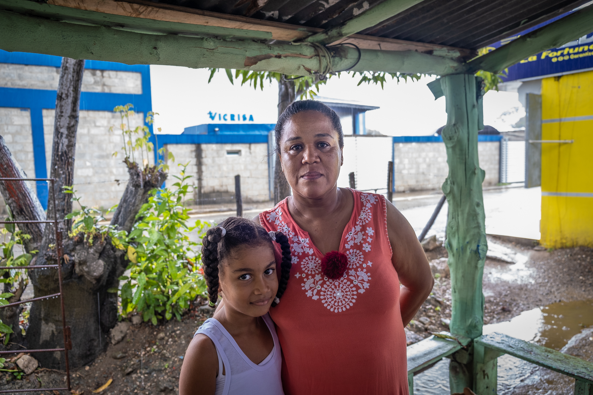 Tomasina Palanco stands with her granddaughter in front of another company in the industrial zone