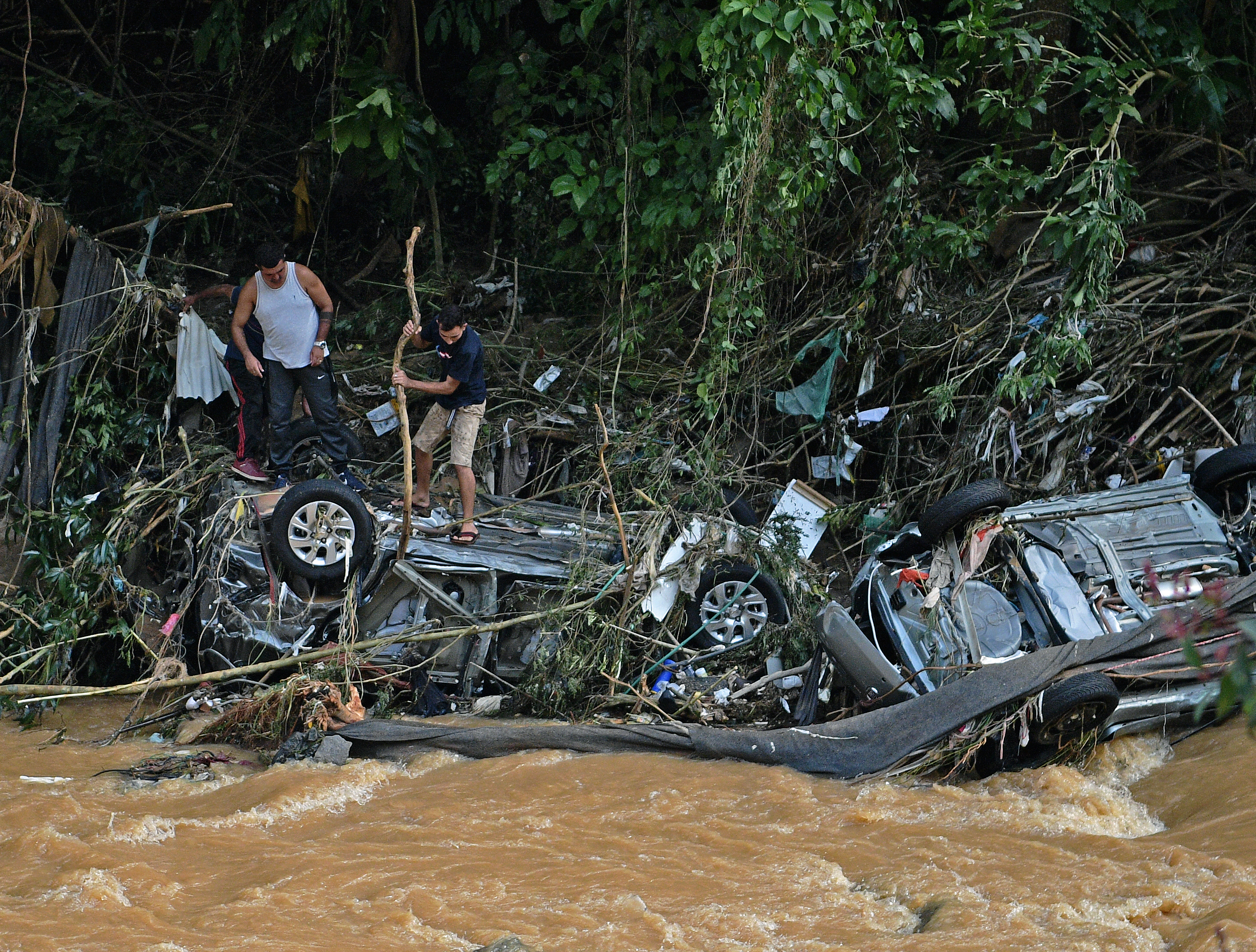 People try to rescue items from cars destroyed by a flash flood in Petropolis