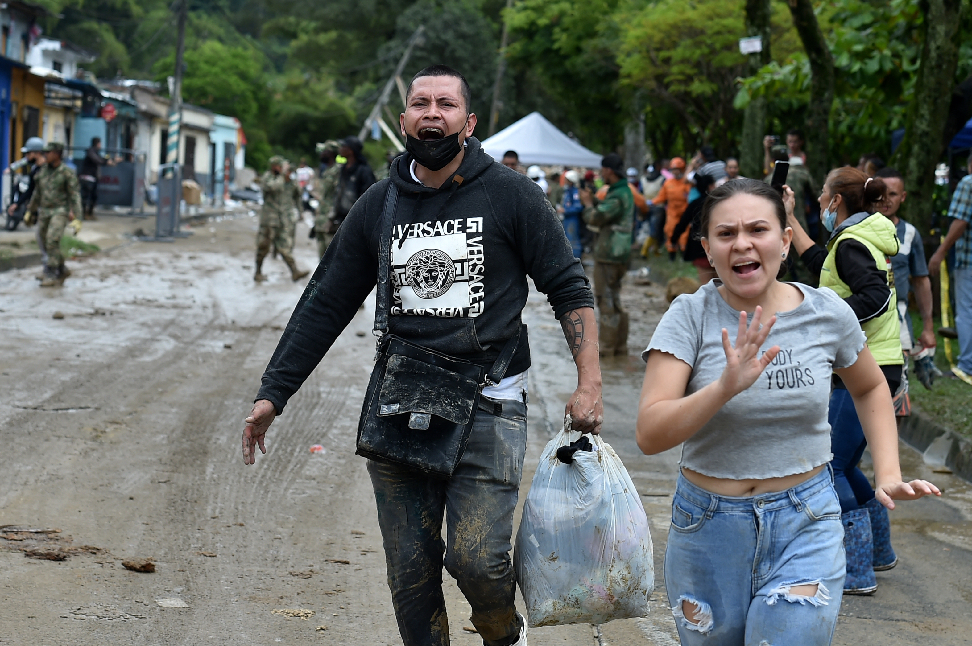 A man and woman run away in panic amid concern of another landslide