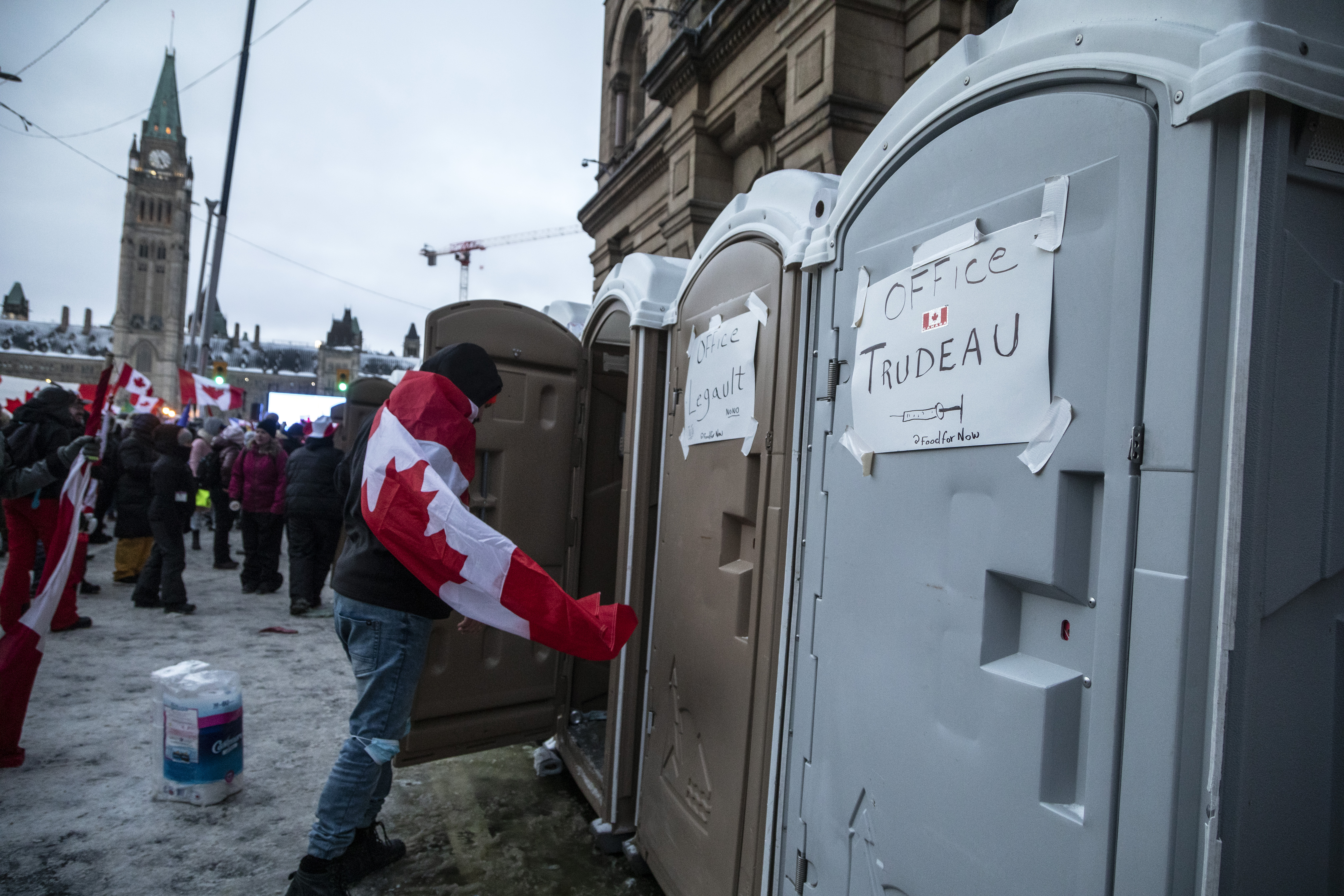 A protester enters one of a series of Port—oPotties installed on Metcalfe street in full view of the Candian Parliament Buildings.