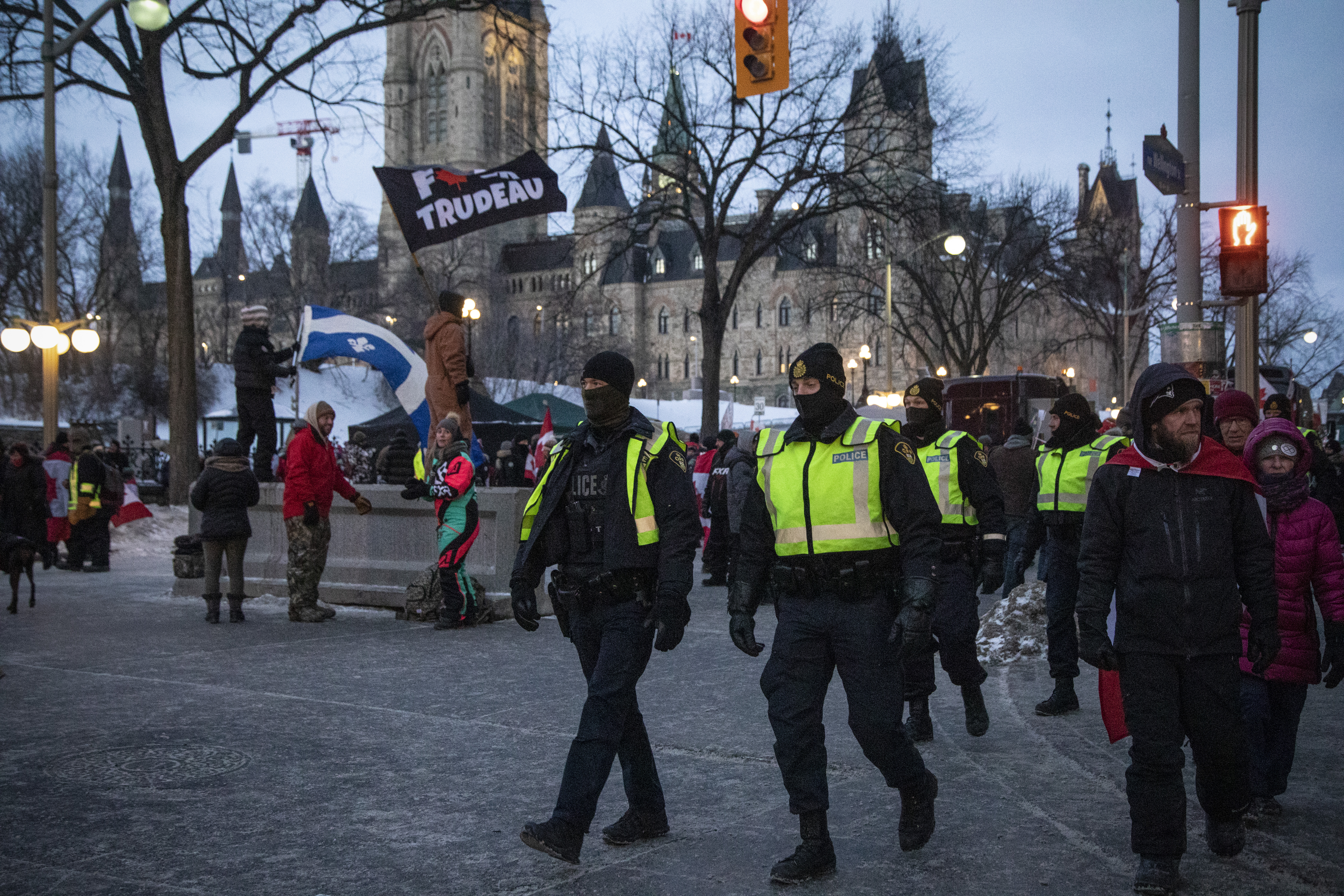 Police officers walk west along Wellington street.