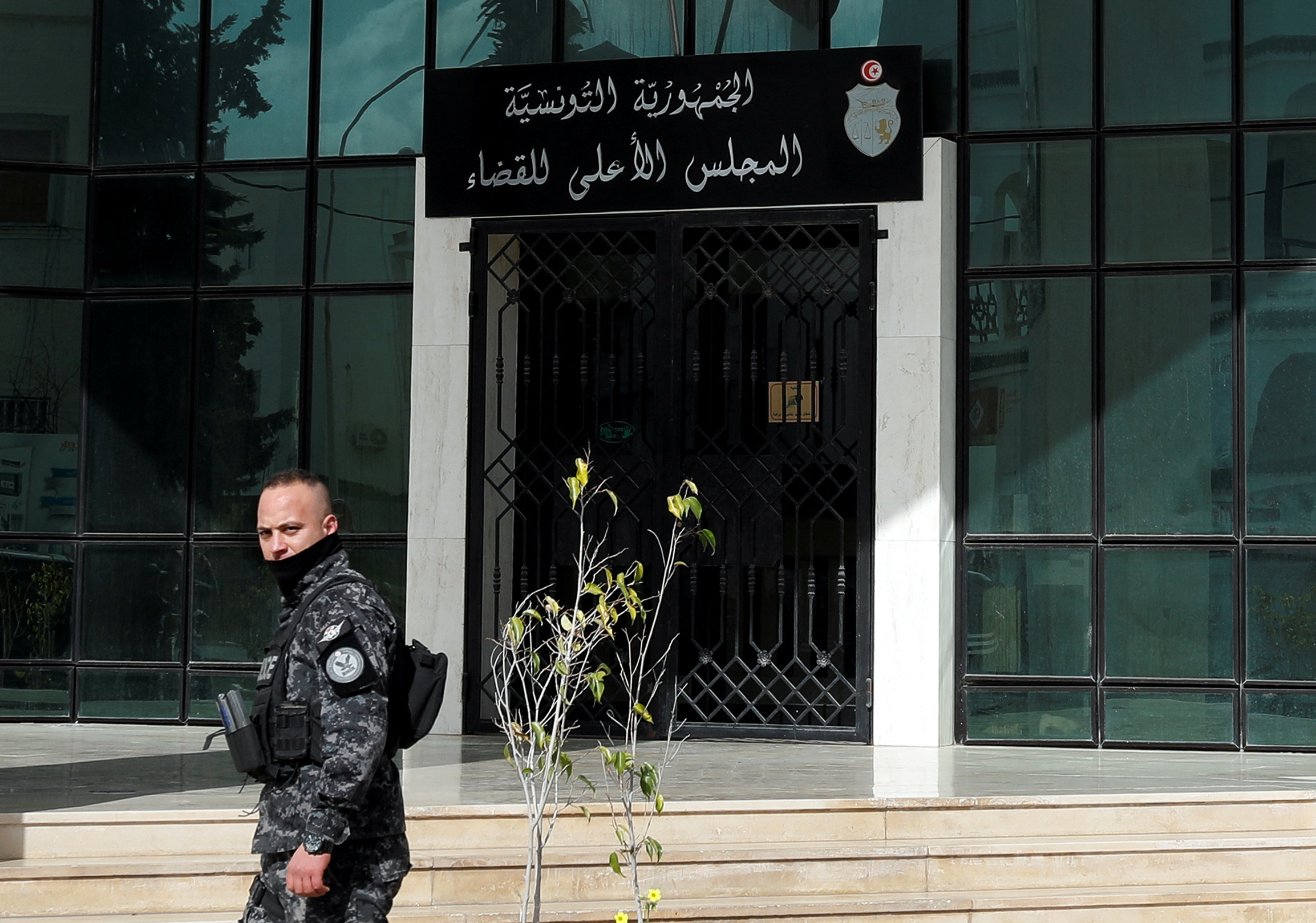Police officer walks outside the Supreme Judicial Council building during a protest in Tunis.