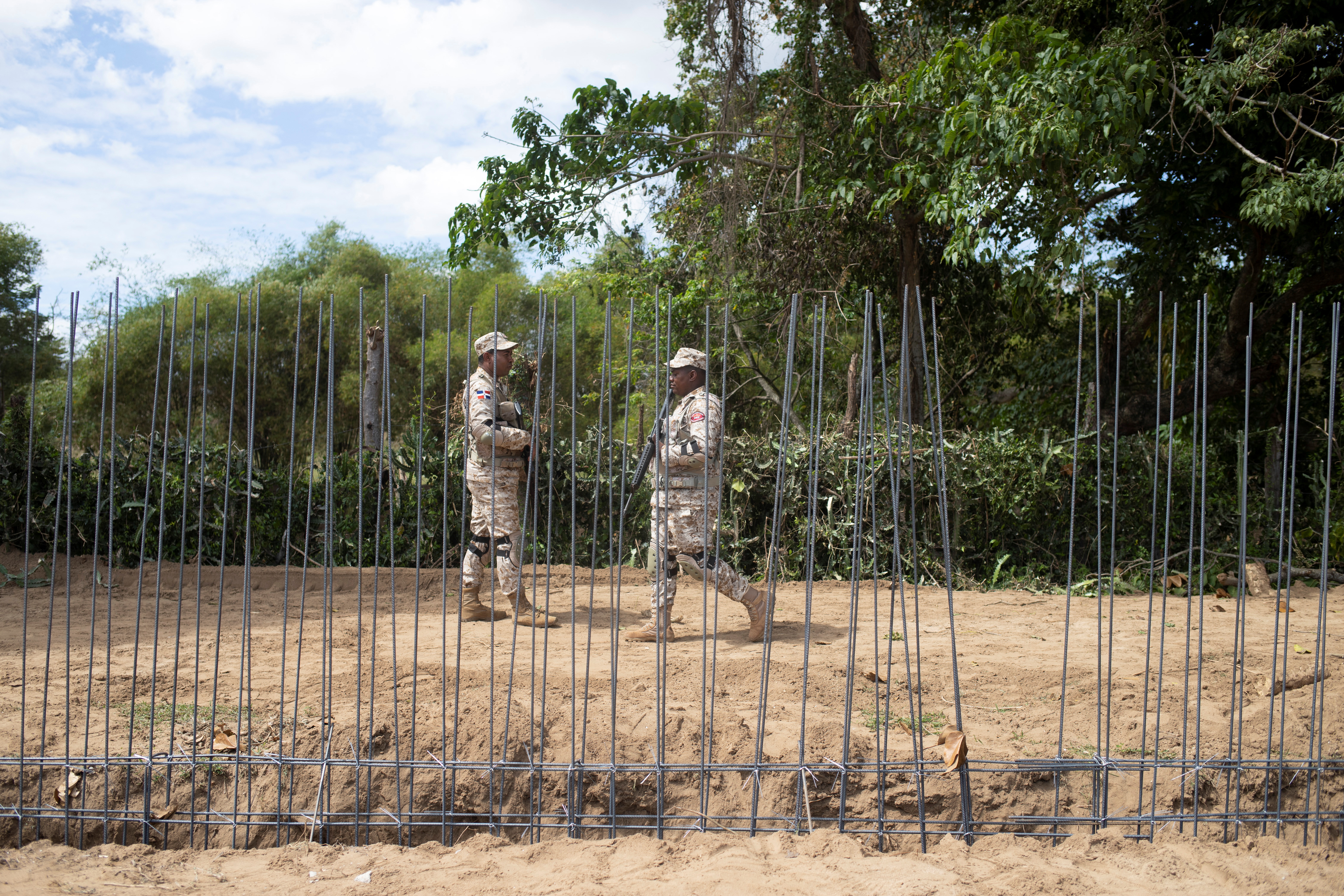 Soldiers waking beside construction of wall