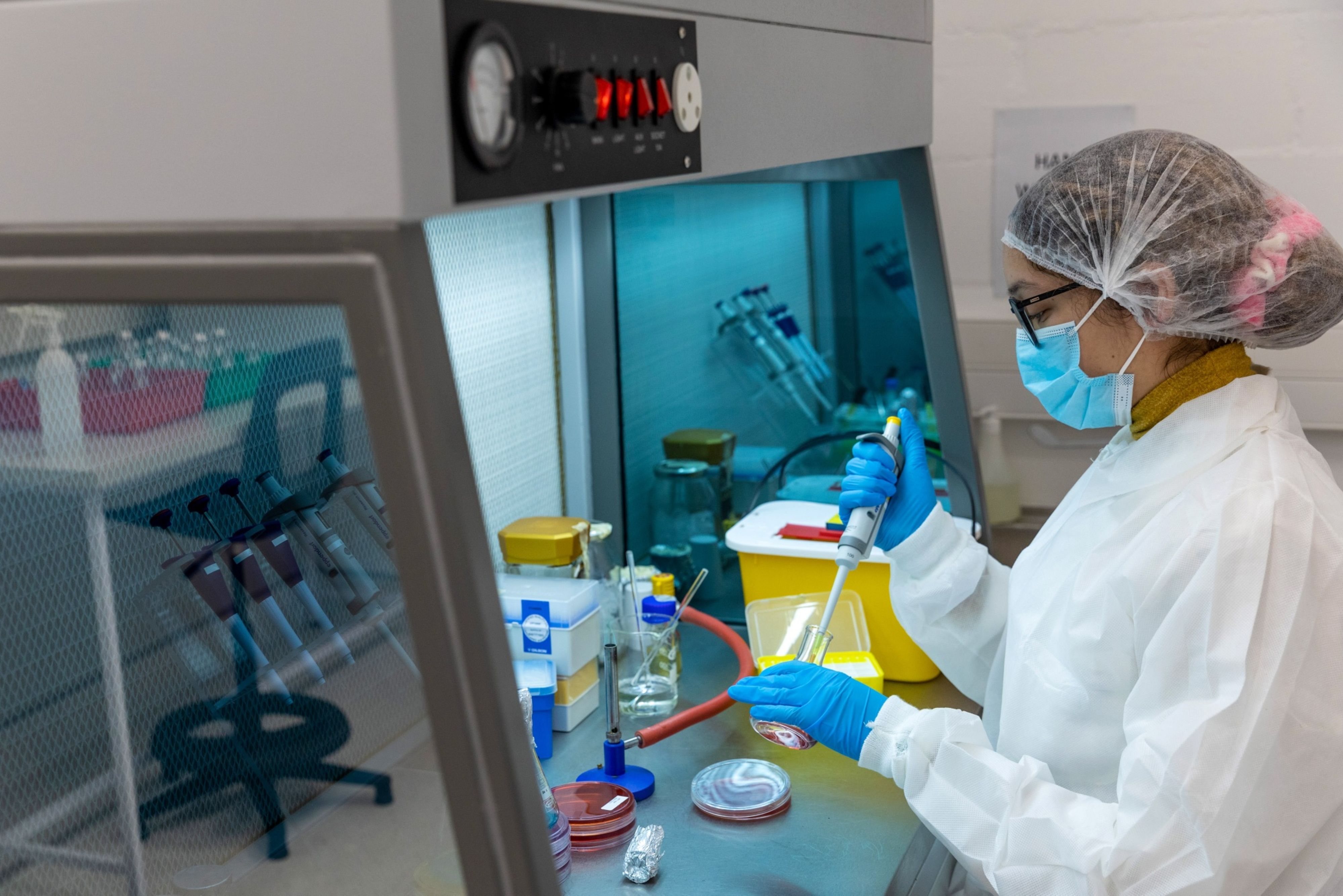 A technician uses a single channel pipette dropper inside the Afrigen Biologics & Vaccines Ltd. laboratory facility in Cape Town