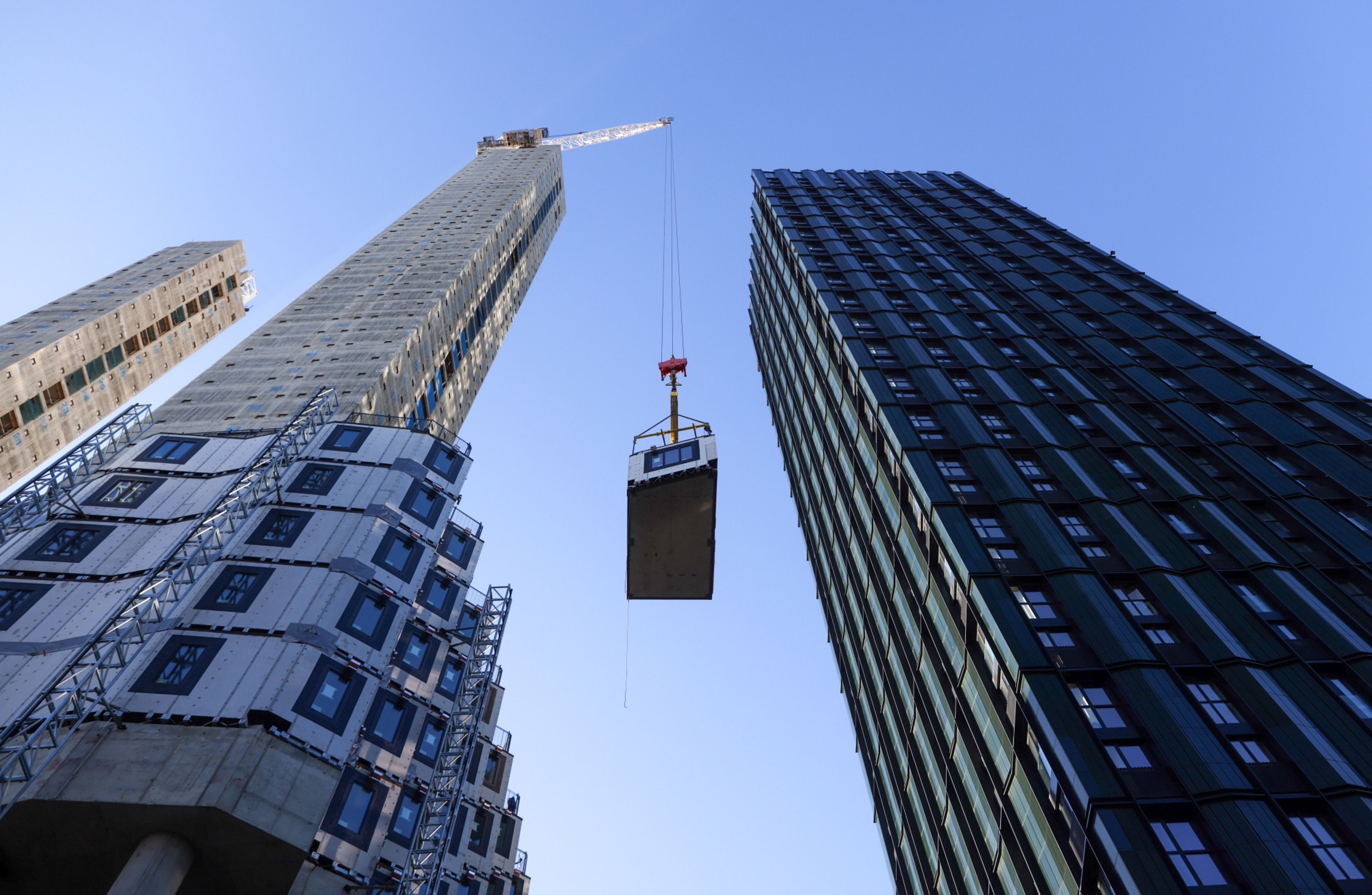 A crane lifts a section of apartment to be fitted into position at a construction site in Croydon, Greater London, U.K.