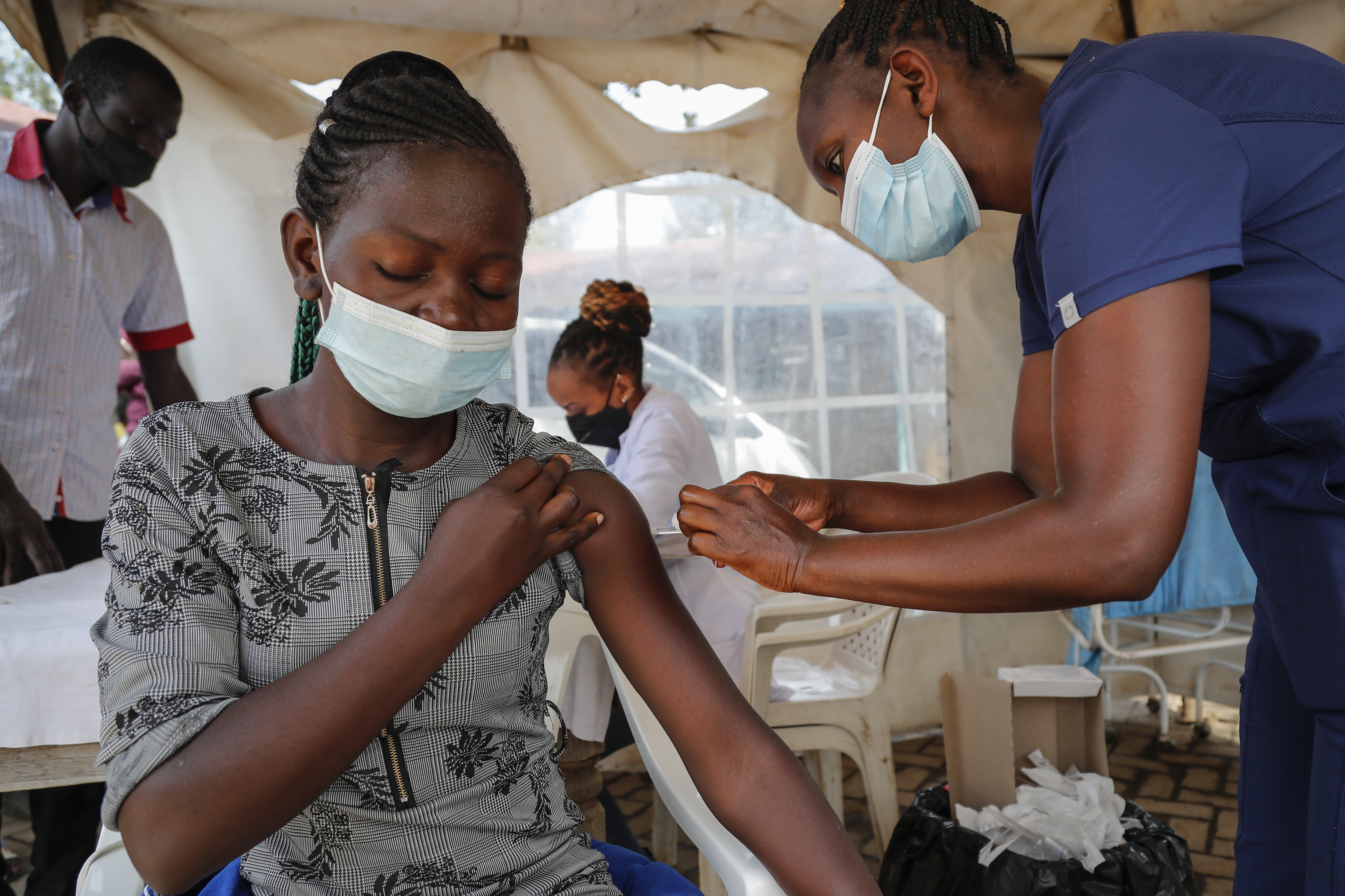 A nurse administers an AstraZeneca vaccination against COVID-19, at a district health center