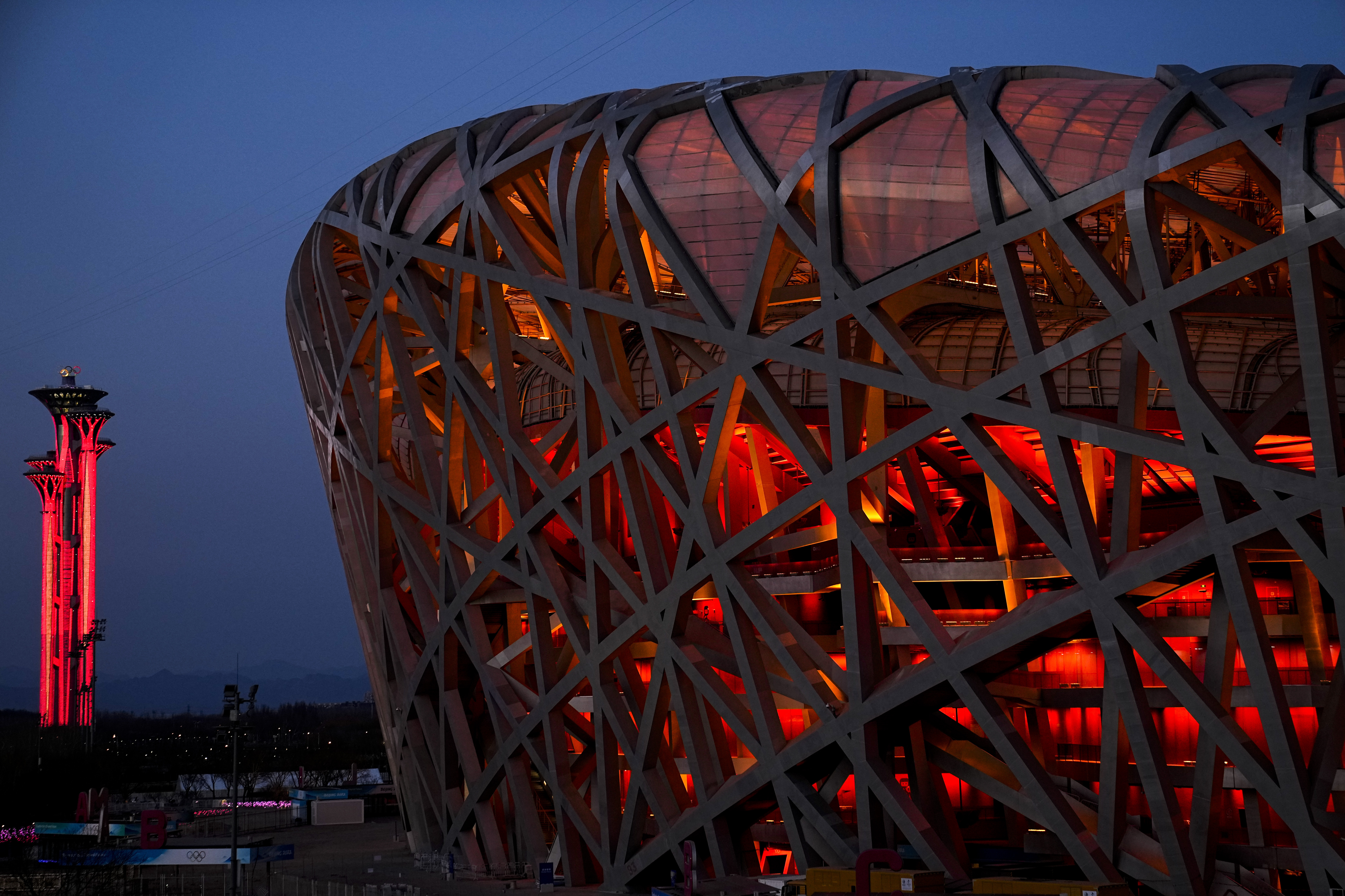 The National Stadium and the Beijing Olympic Tower are lit in red
