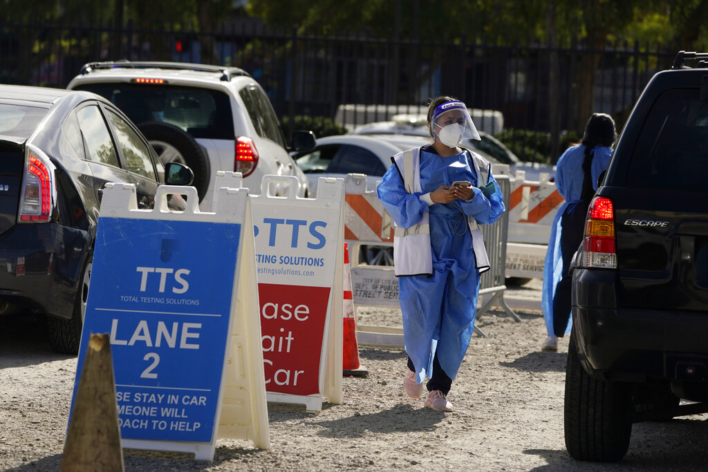 Workers wear protective equipment at a COVID-19 testing site in the Boyle Heights section of Los Angeles.