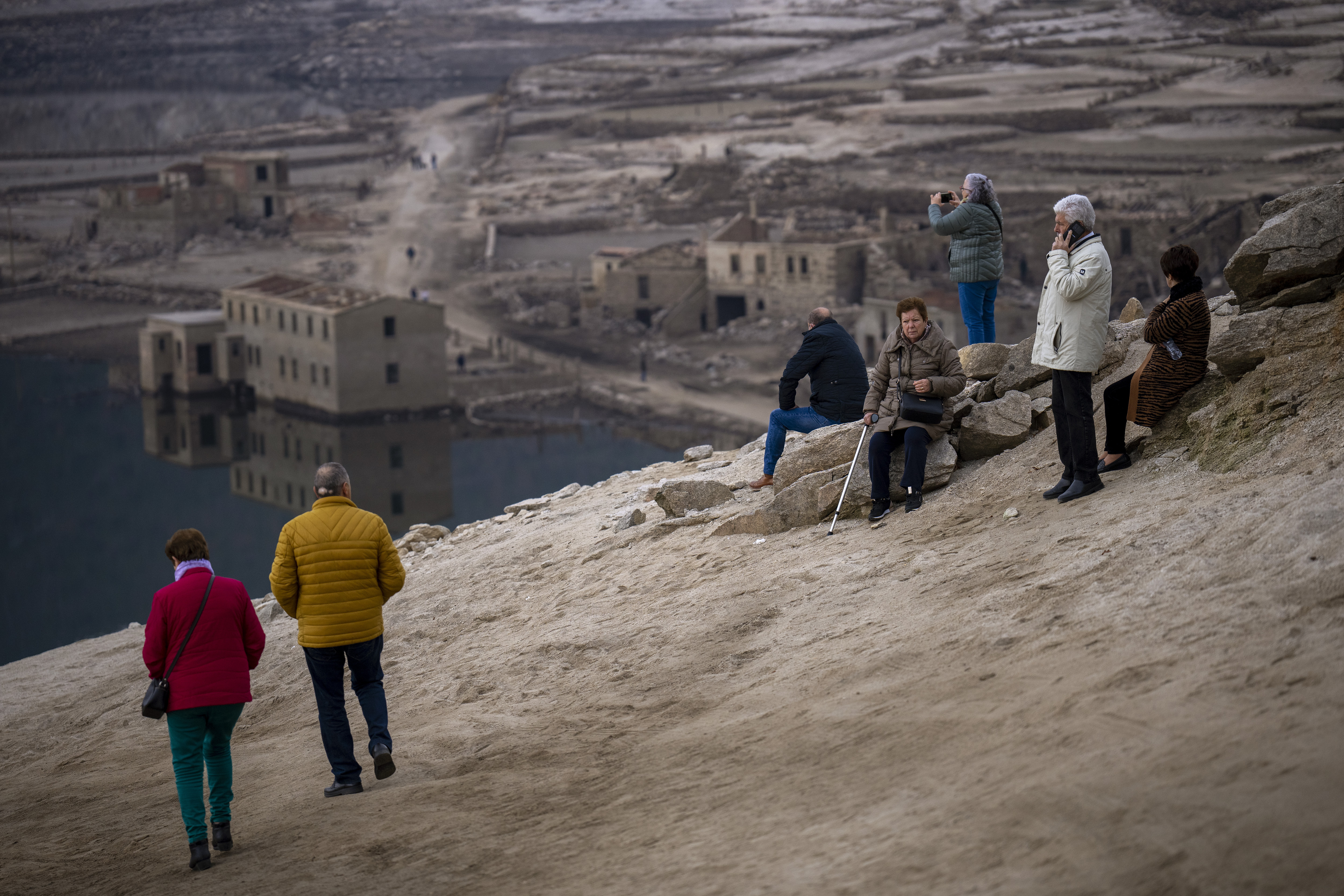 Visitors look at the old village of Aceredo emerged due to drought at the Lindoso reservoir, in northwestern Spain