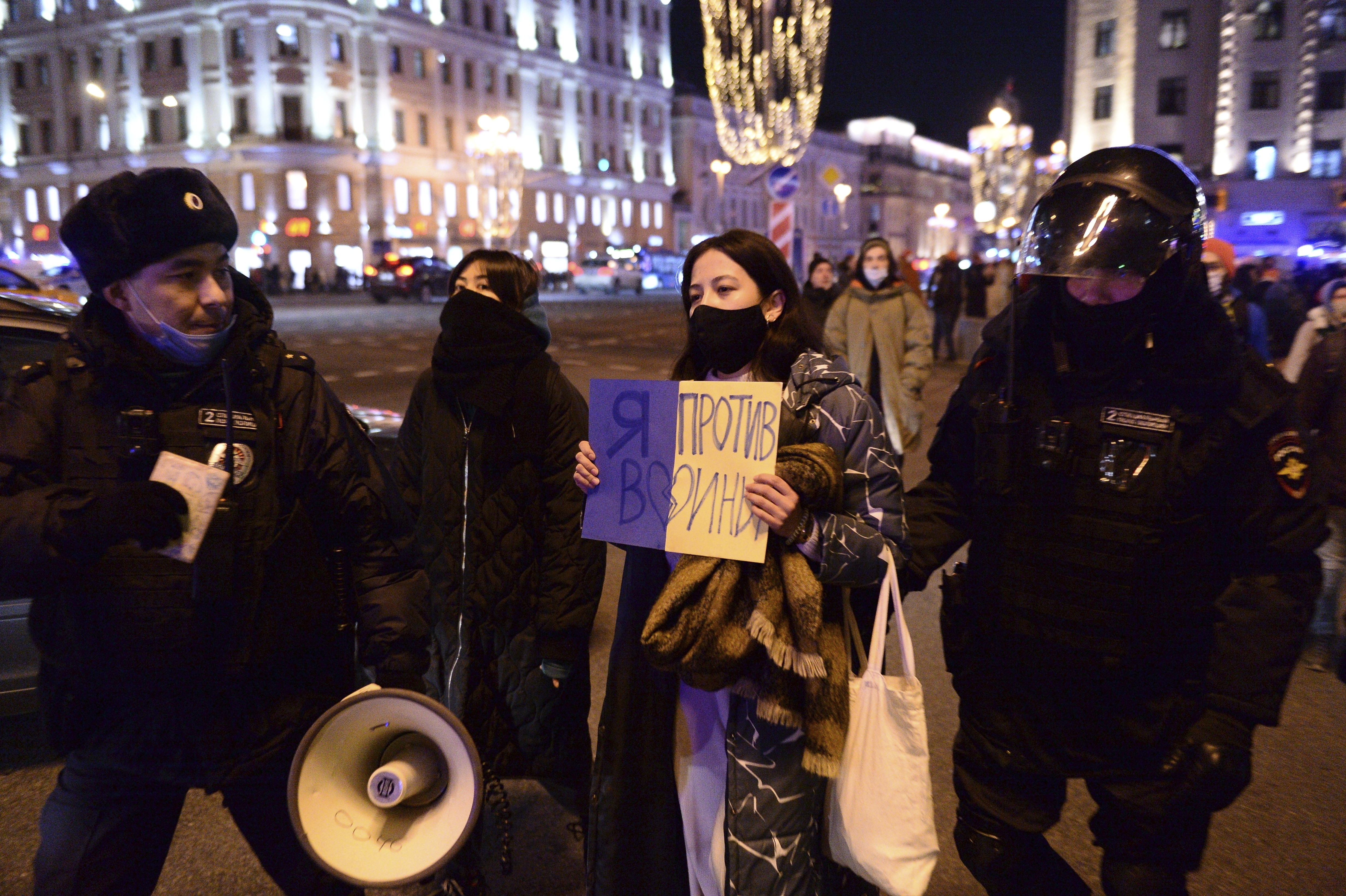 Police officers detain a demonstrator with a poster that reads: "I'm against the war", in Moscow