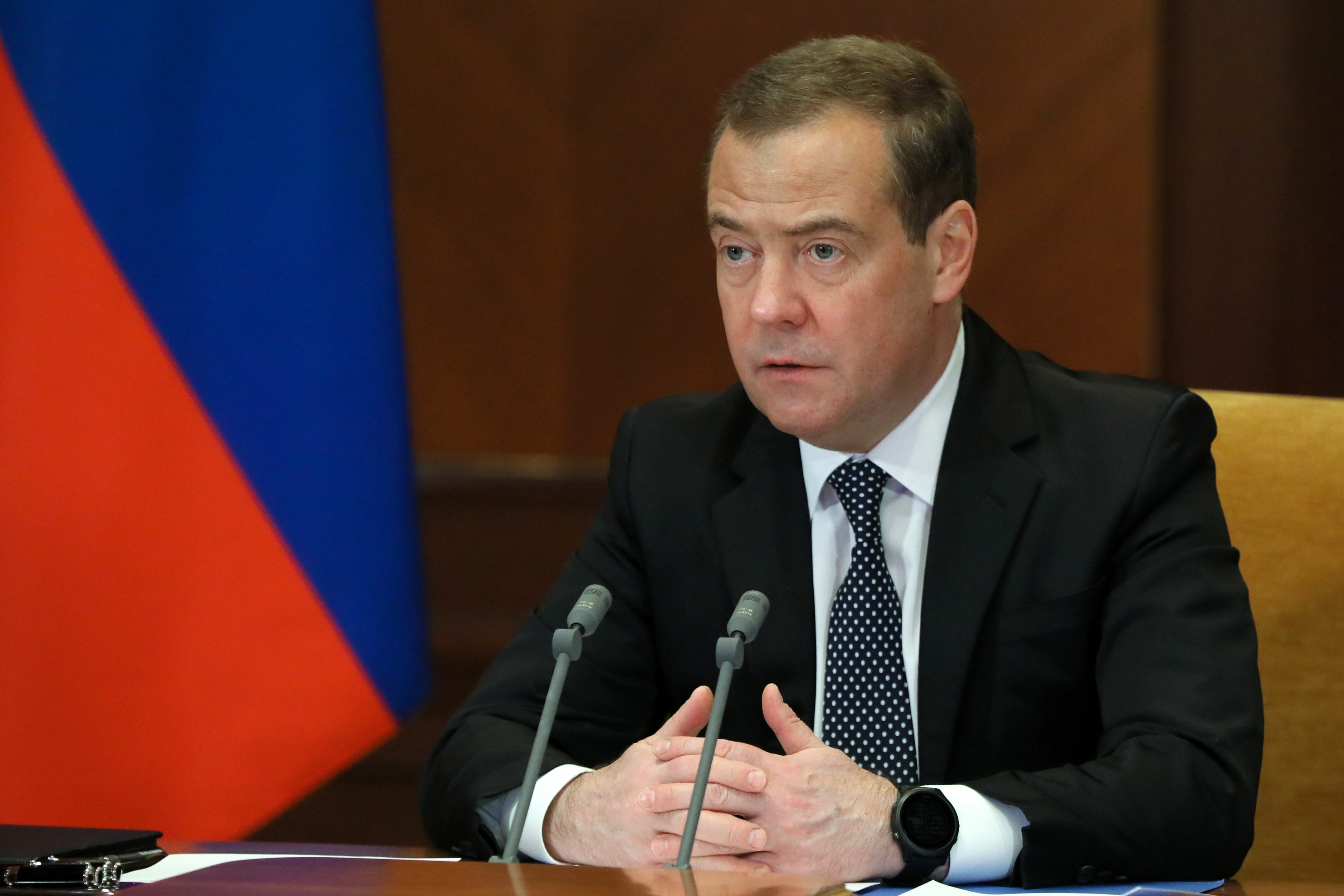 Dmitry Medvedev is seen speaking in front of a microphone