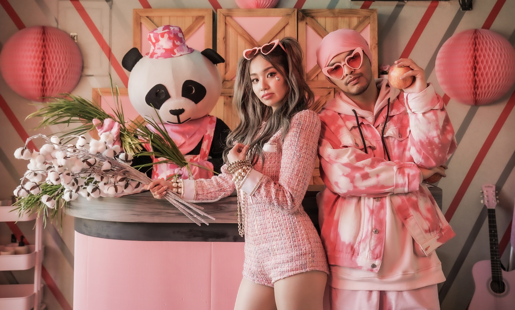 Namewee and Kimberly Chen dressed in pink with a stuffed panda from the video for Fragile.