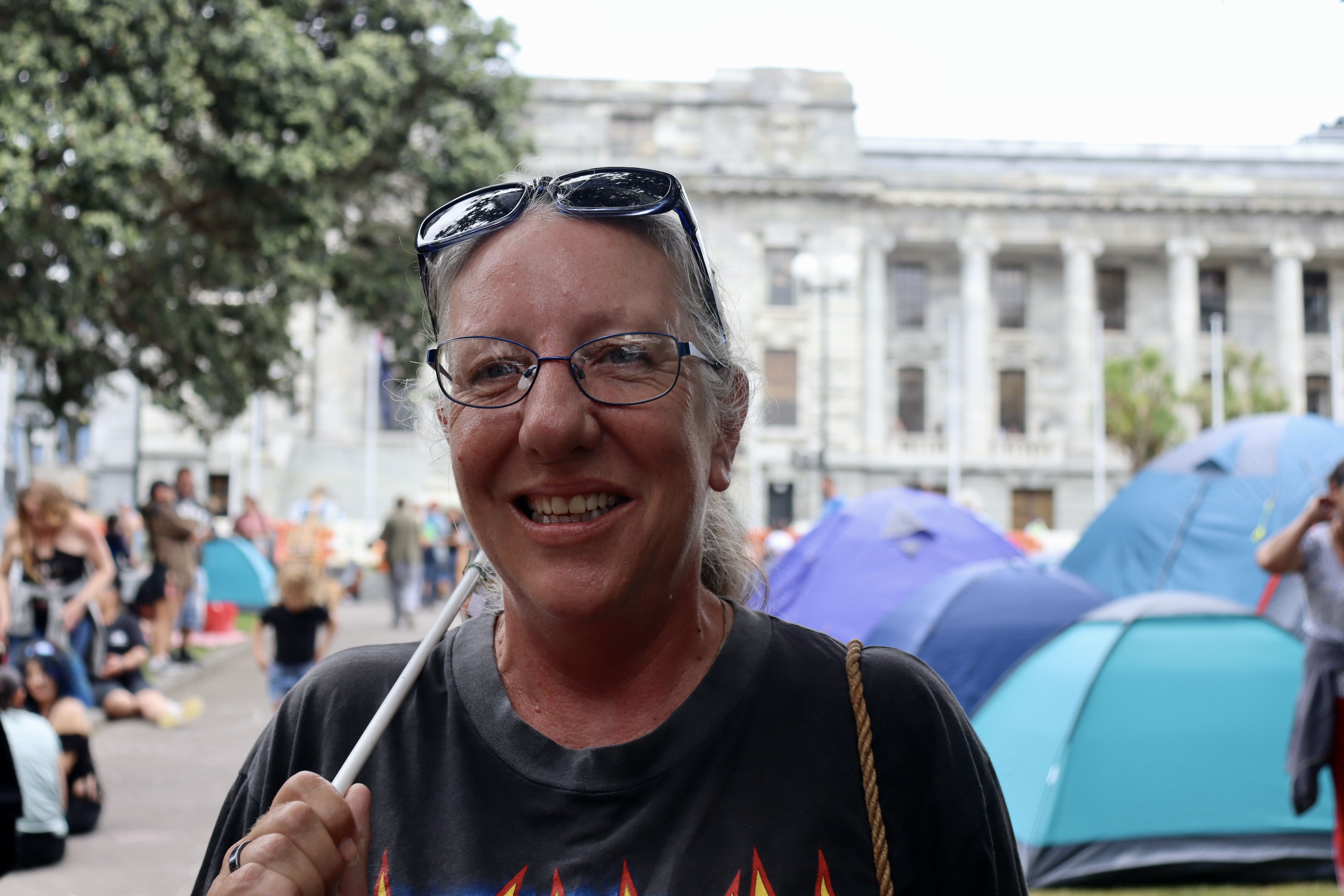 Nicky Booth with sunglasses perched on her head and wearing a black t-shirt is one of the protesters