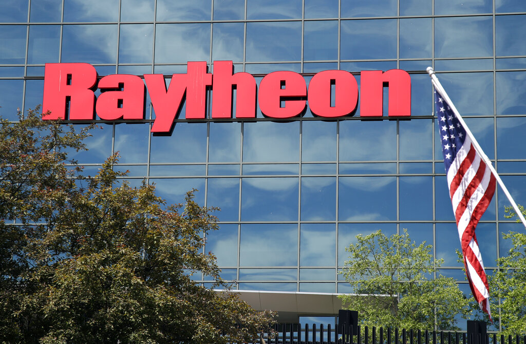 An American flag flies in front of the facade of Raytheon's Integrated Defense Systems facility