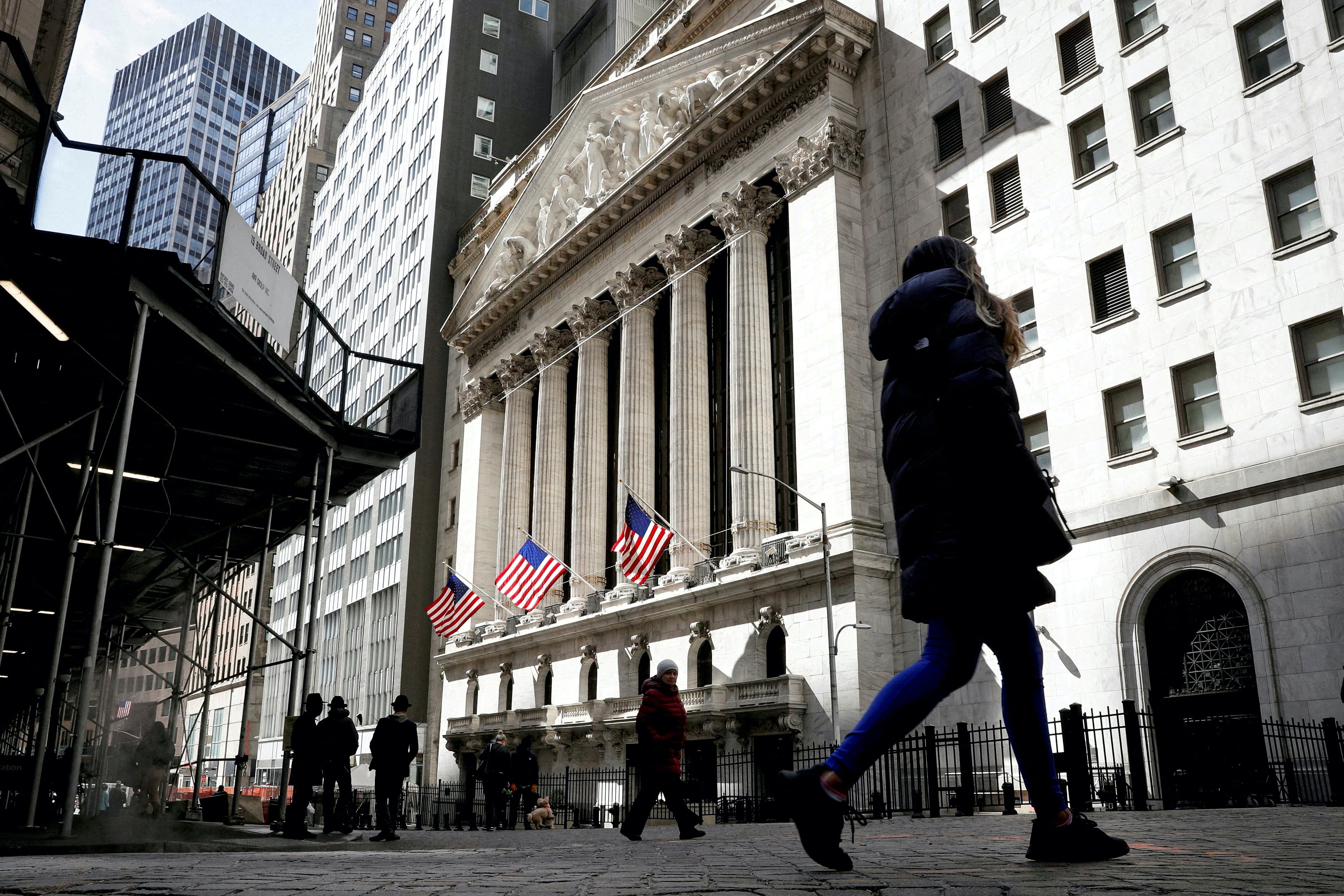 People are seen on Wall Street outside the New York Stock Exchange