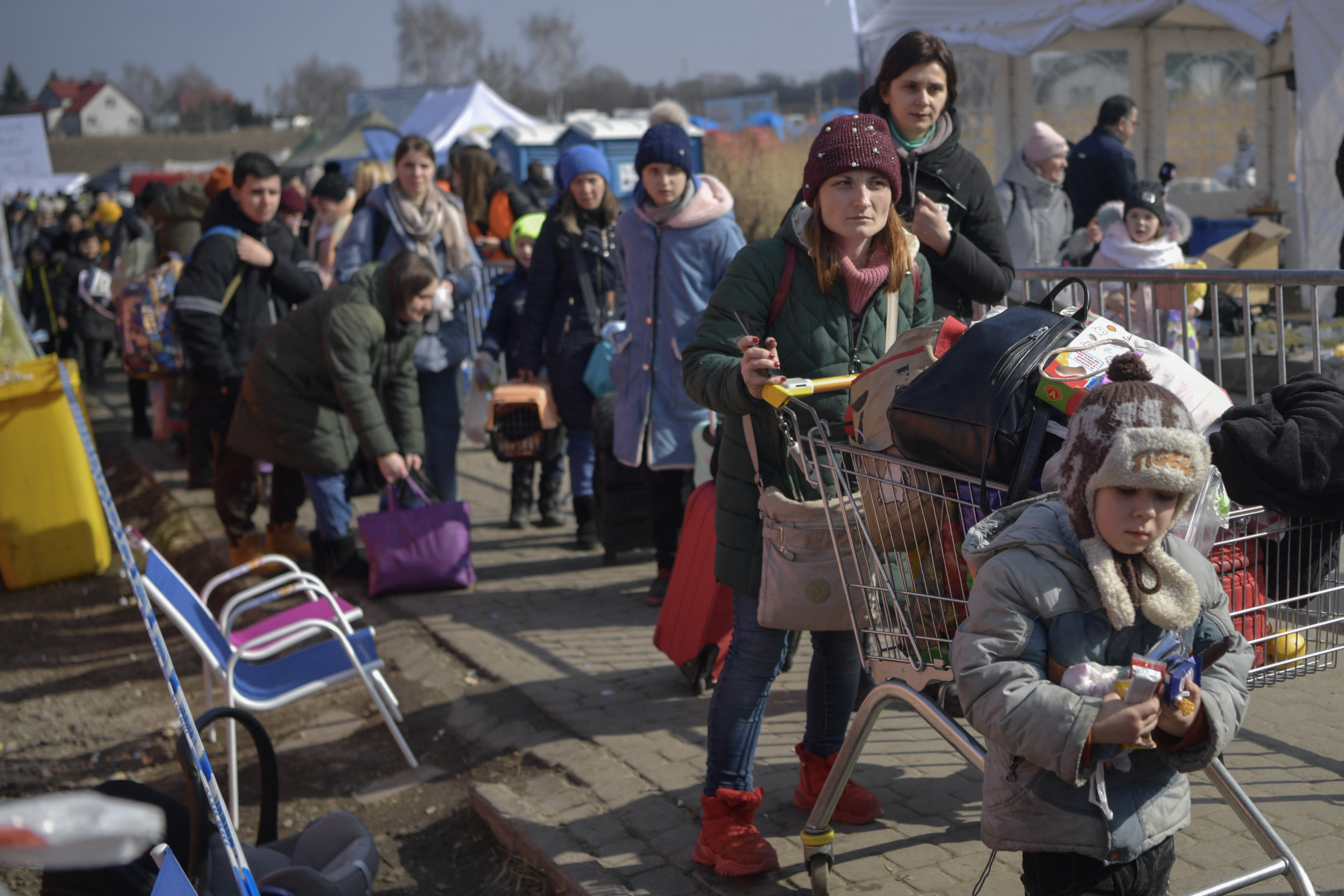People walk to take further transportatipon after crossing the Ukrainian border into Poland