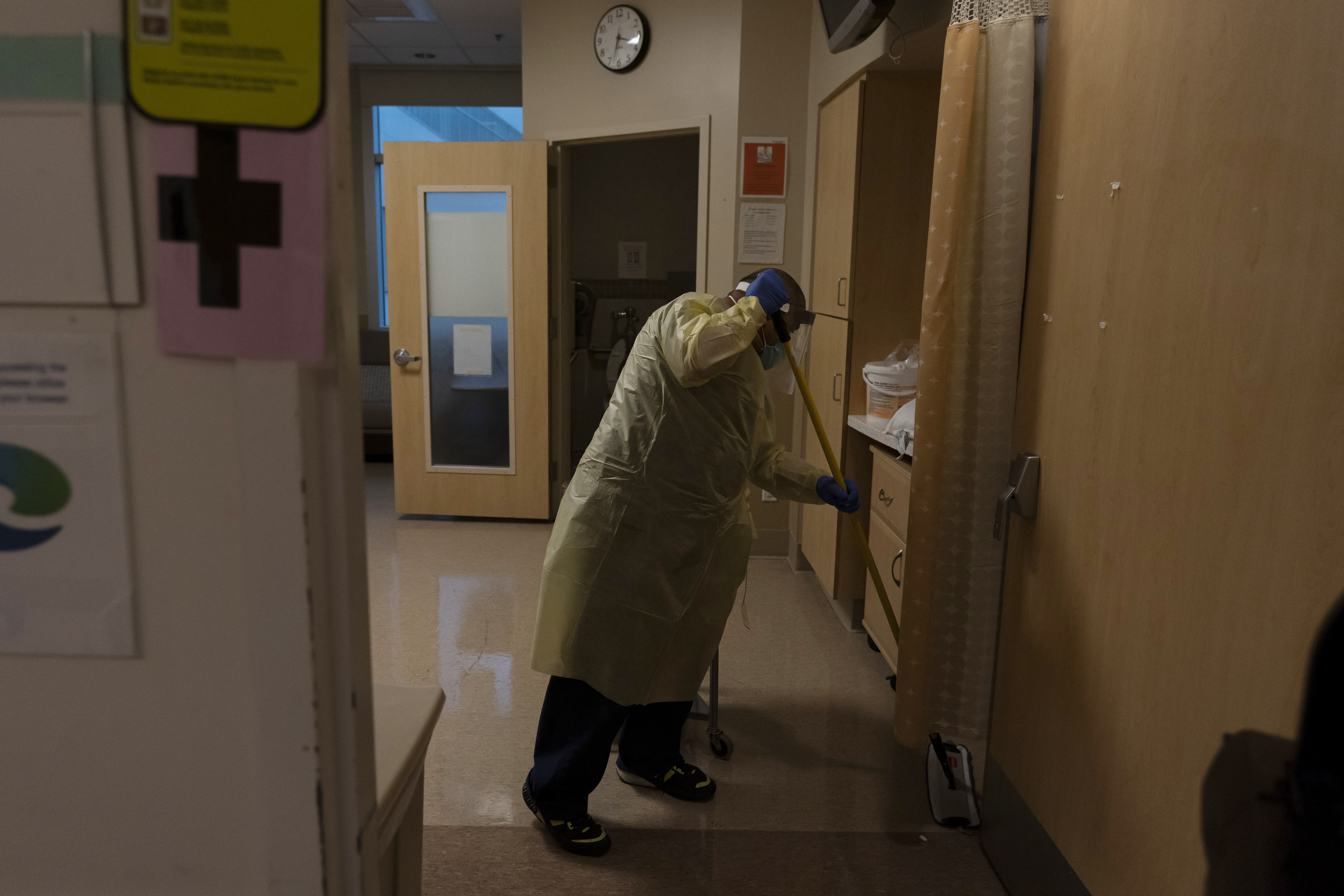 Environmental technician Gerardo Velazquez cleans a room after a COVID-19 patient was transferred to an intensive care unit