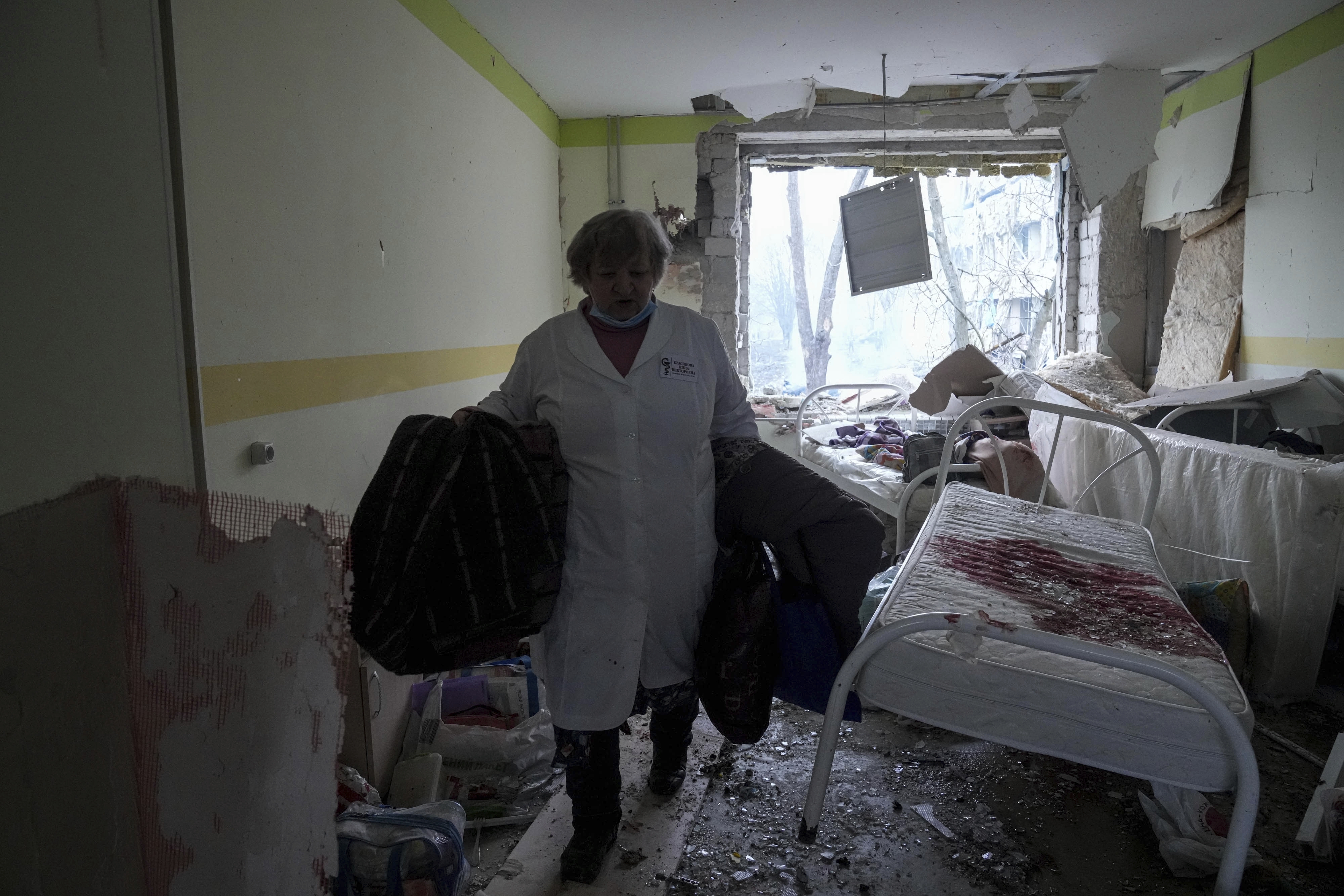 A medical worker walks inside of the damaged by shelling maternity