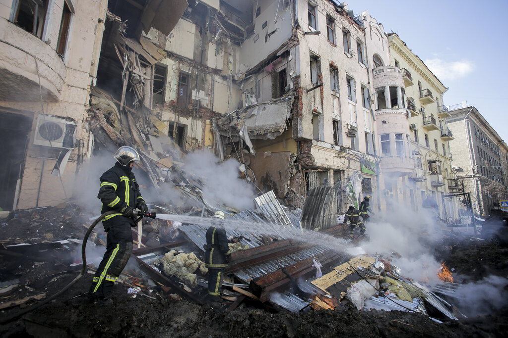 Firefighters are seen working in the rubble of an apartment block after a Russian rocket attack in Kharkiv