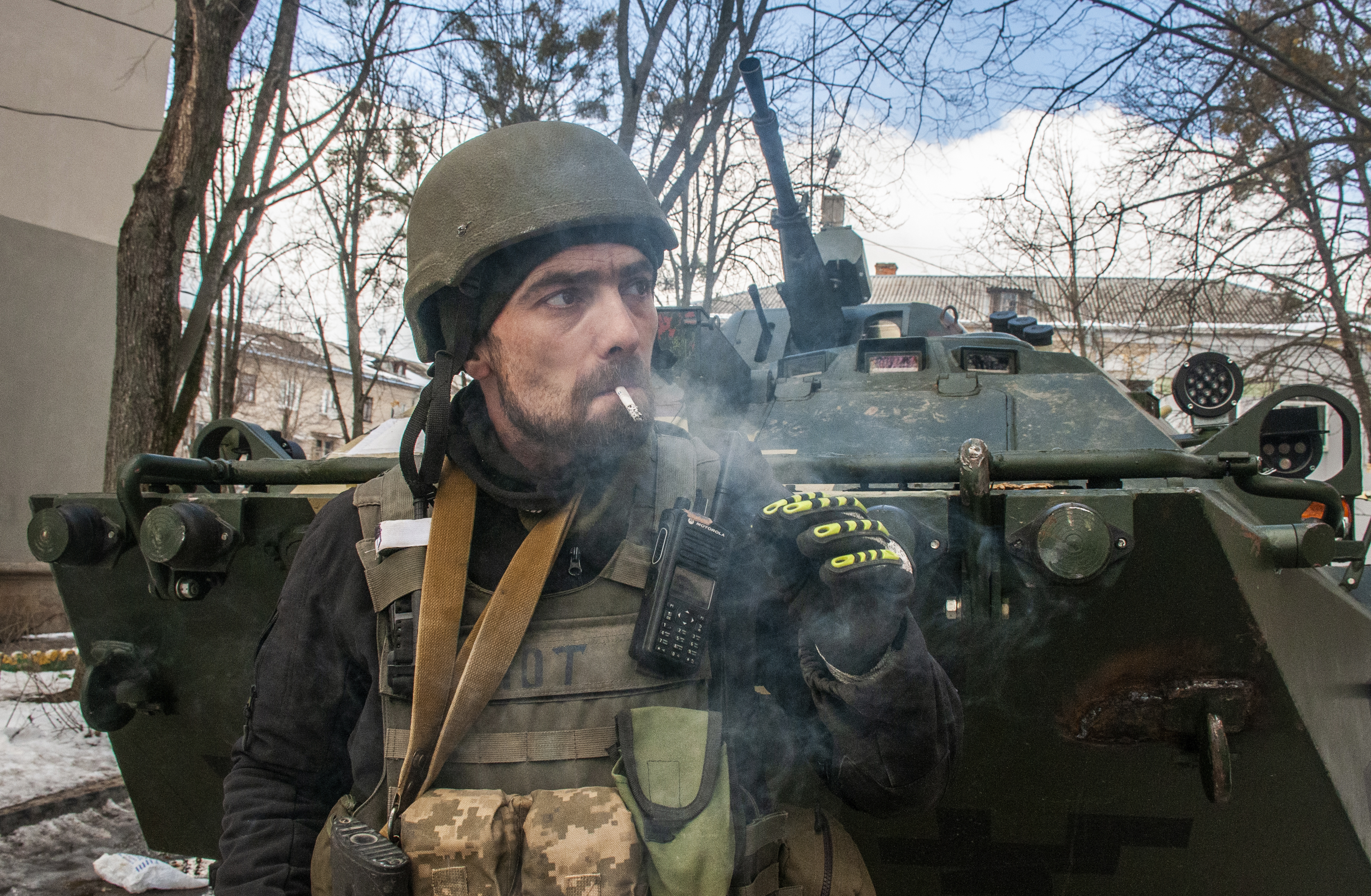 A volunteer of the Ukrainian Territorial Defense Forces stands next to his APC in Kharkiv